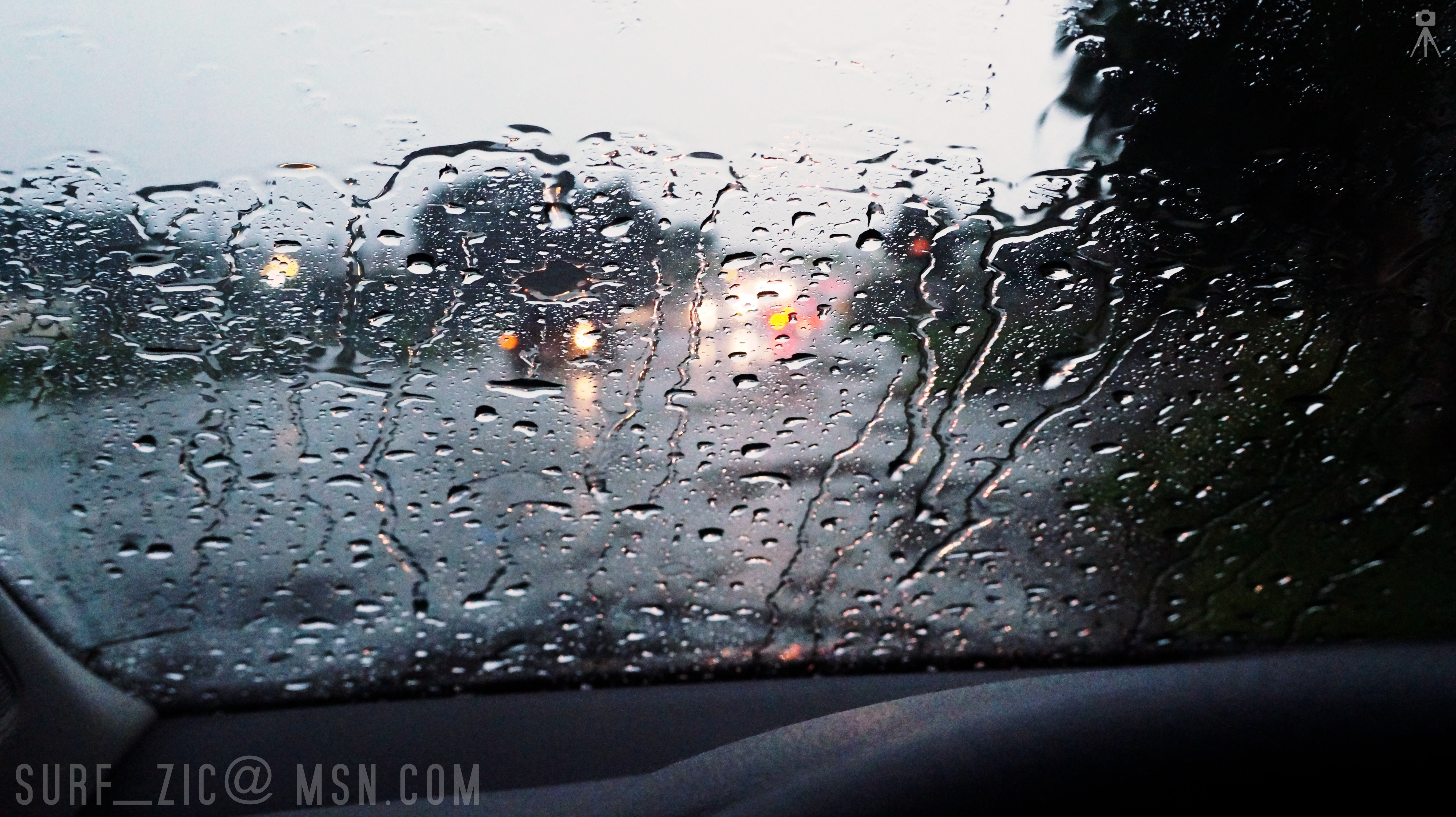 Raindrops on a car window with blurred lights HD Wallpaper
