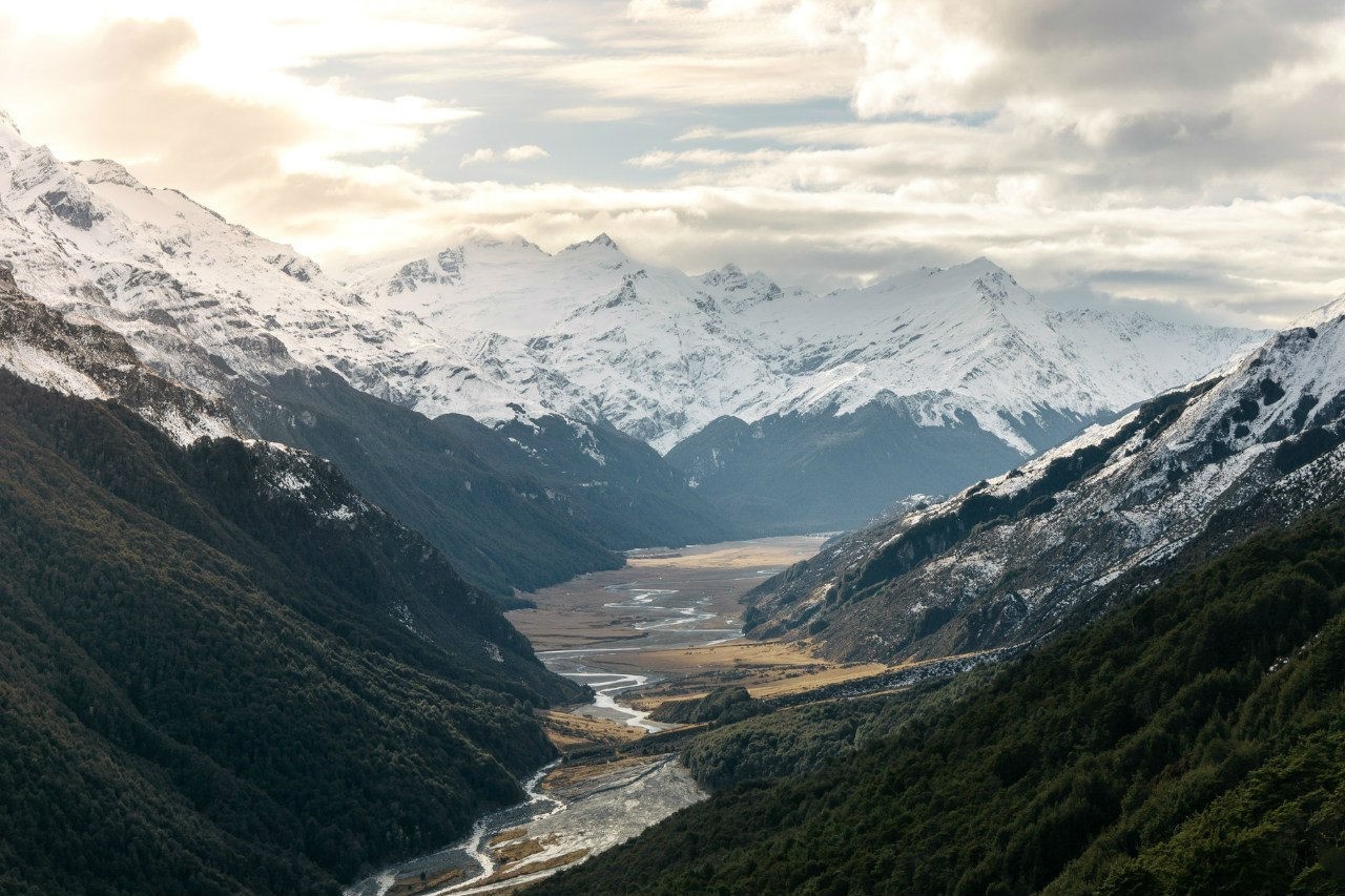 Snow-capped mountains and a winding river valley HD Wallpaper