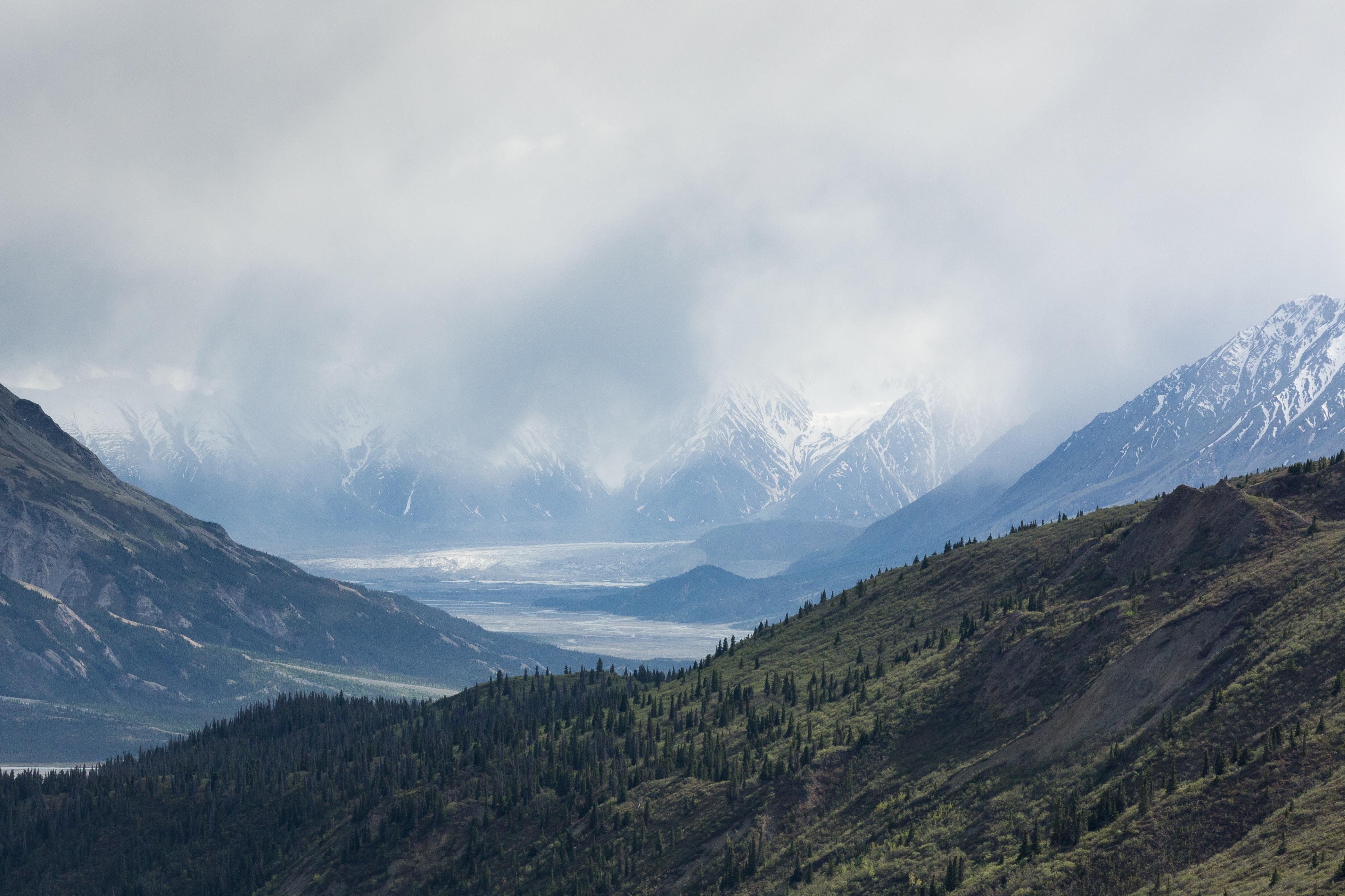 Mountain valley with snow-capped peaks and clouds HD Wallpaper
