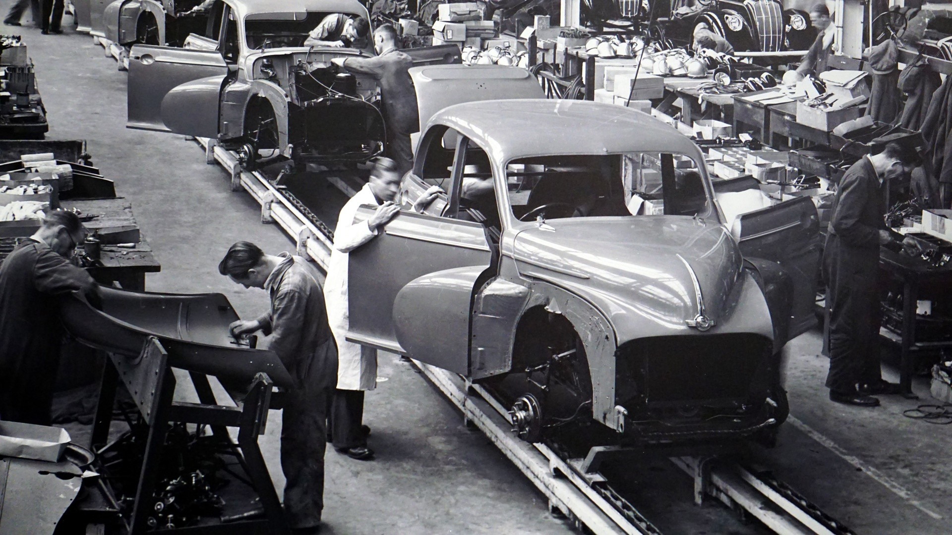 Men working on cars on an assembly line in a factory HD Wallpaper