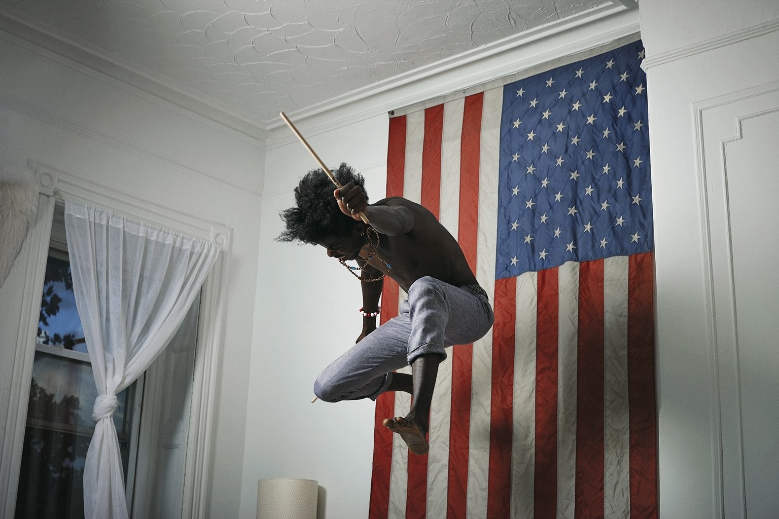 Man with drumstick jumping in front of American flag HD Wallpaper