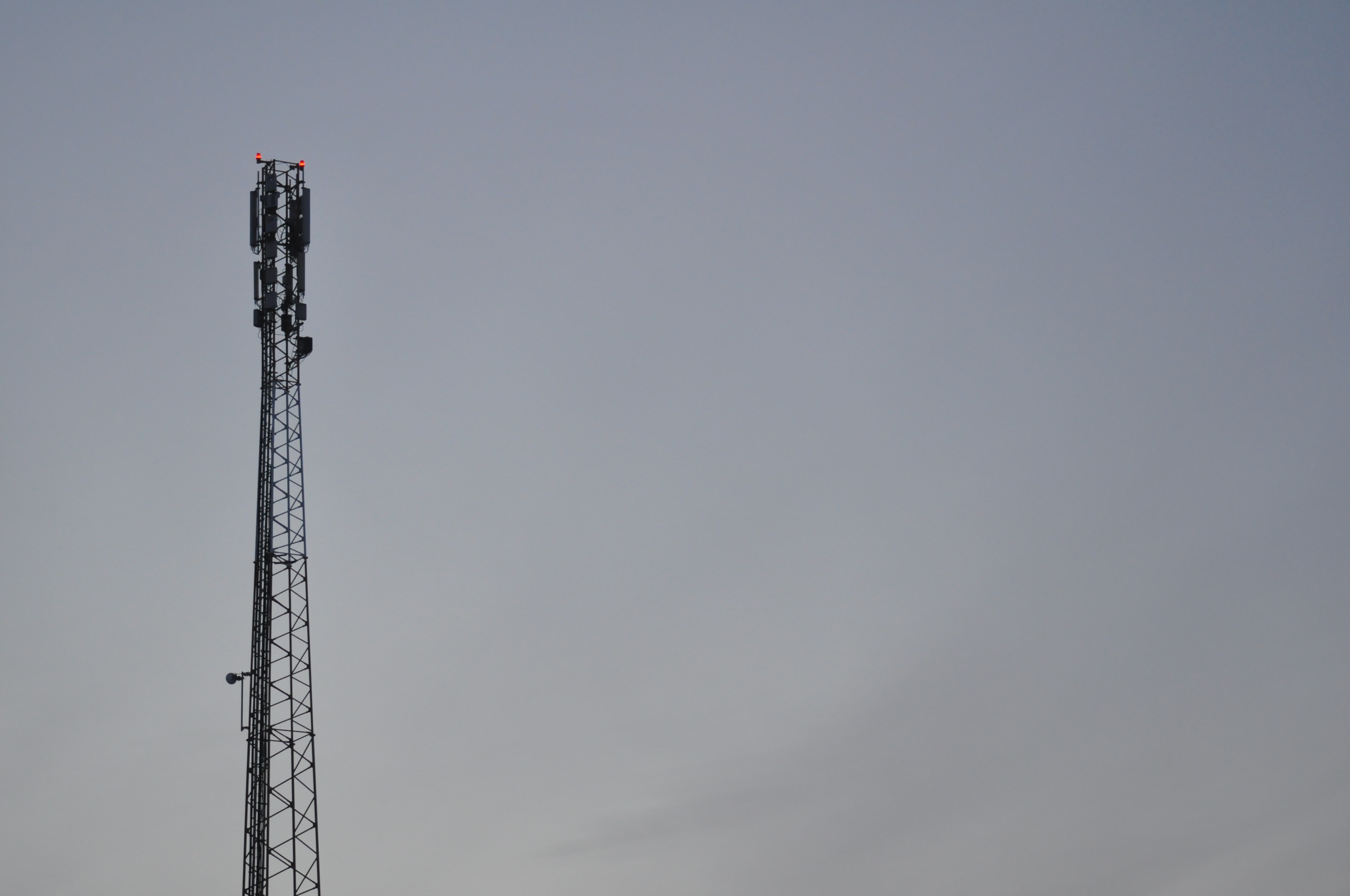 Cell tower against a pale sky HD Wallpaper