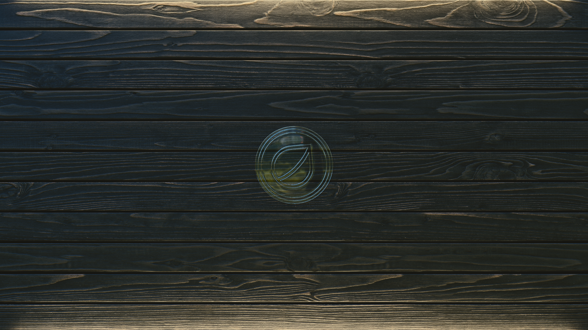 Dark wood planks with a circular logo HD Wallpaper