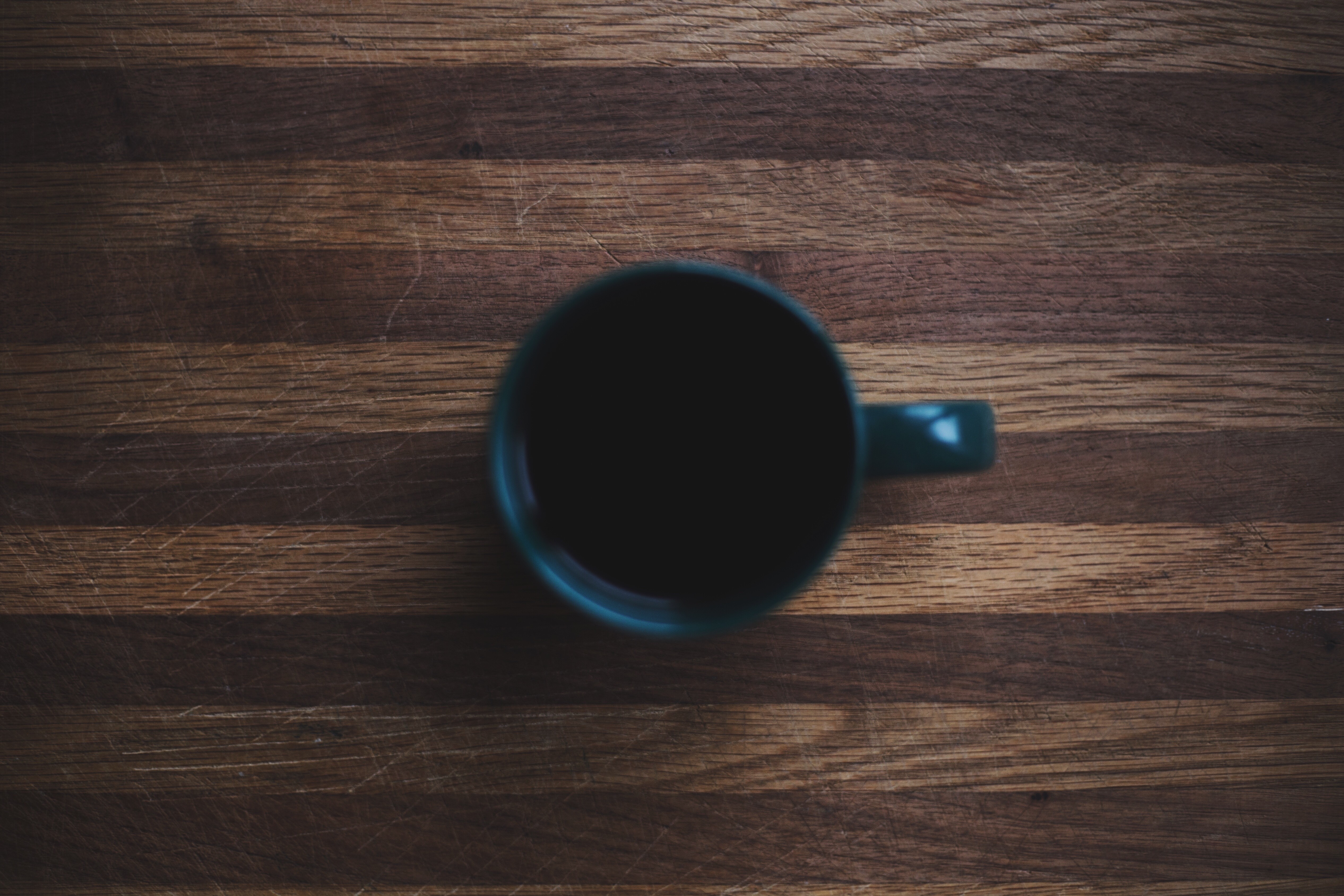 A dark mug of coffee on a wooden surface HD Wallpaper