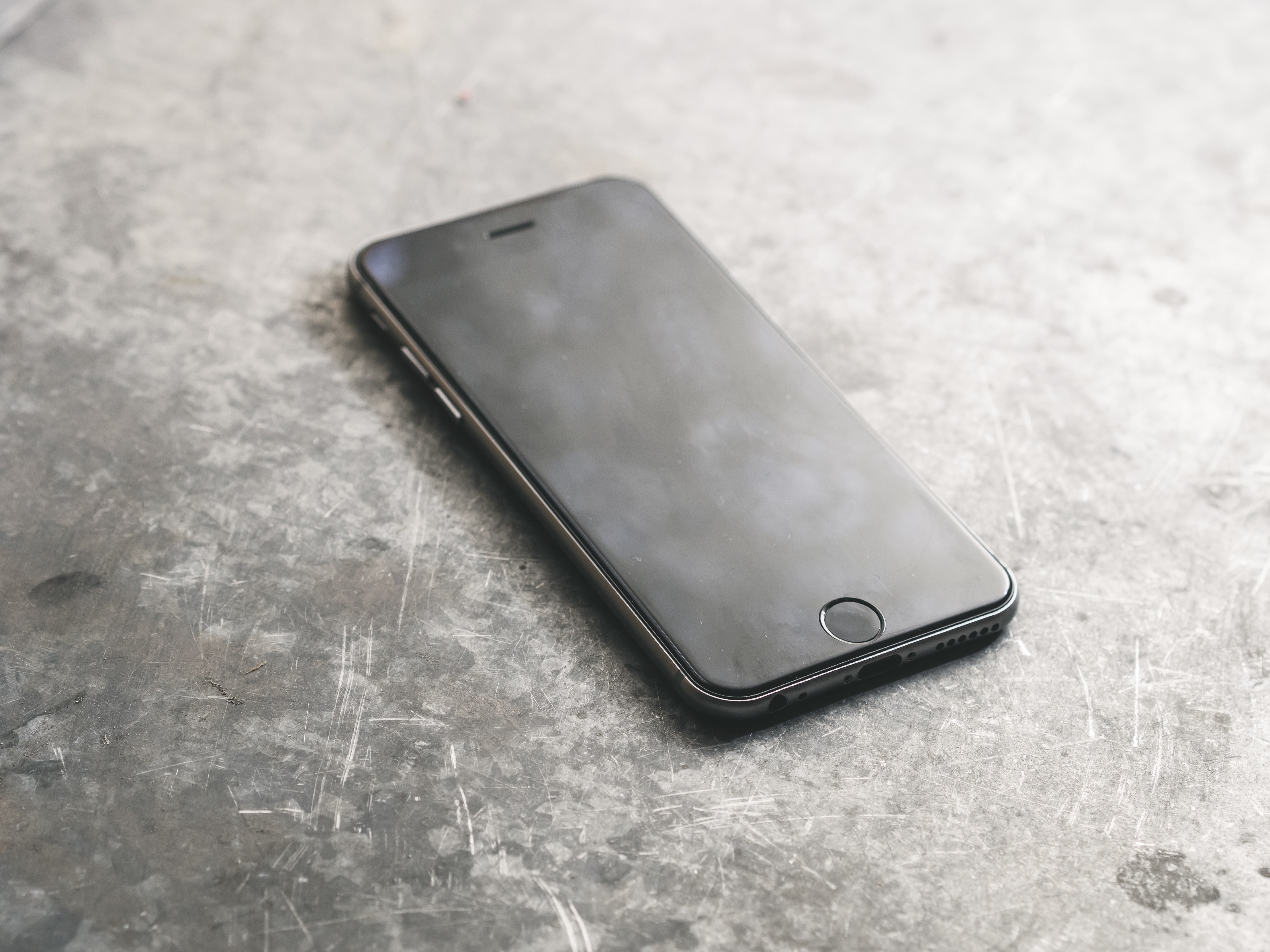 Black iPhone on a metal surface HD Wallpaper
