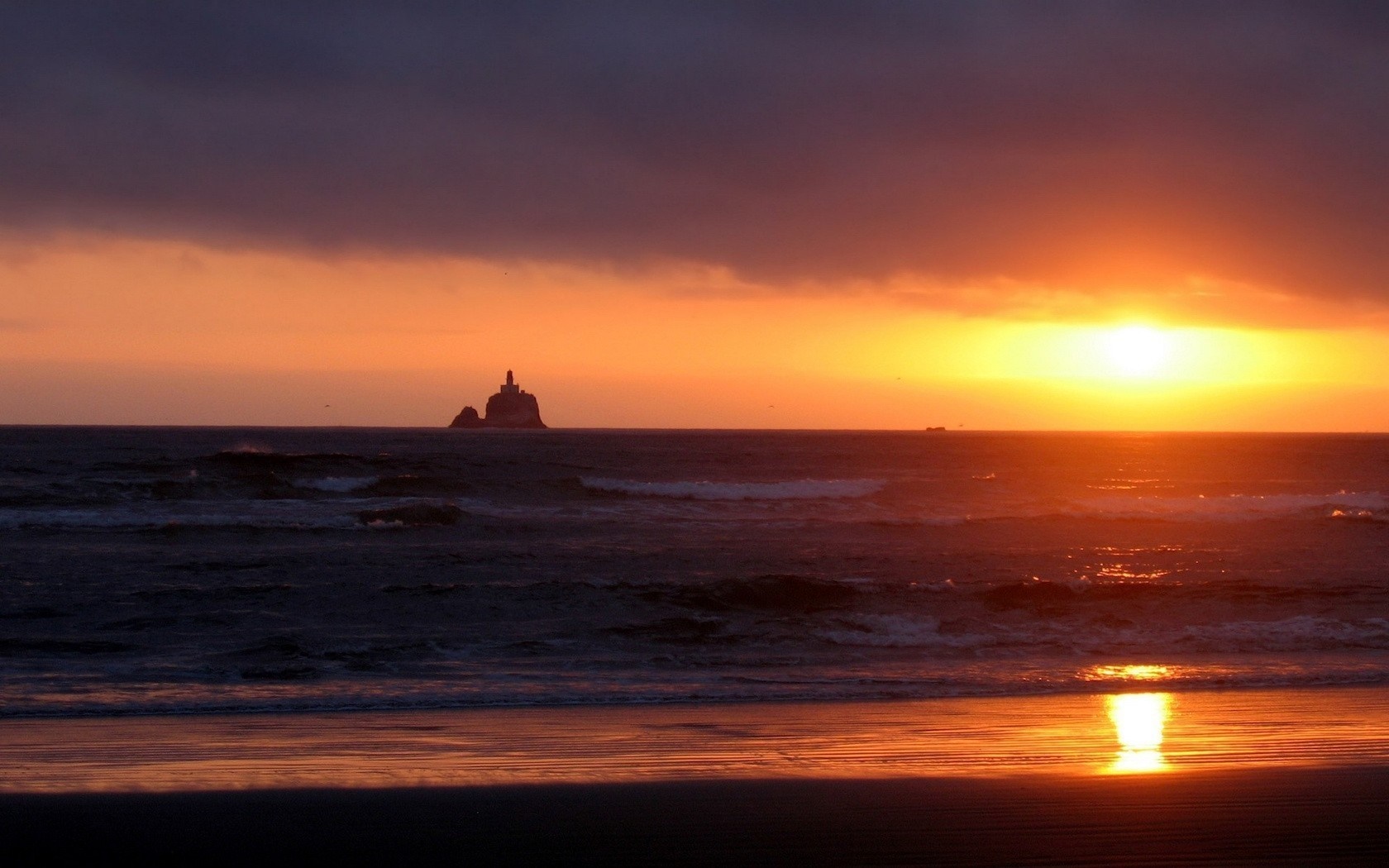 Sunset over the ocean with a lighthouse on a rock HD Wallpaper