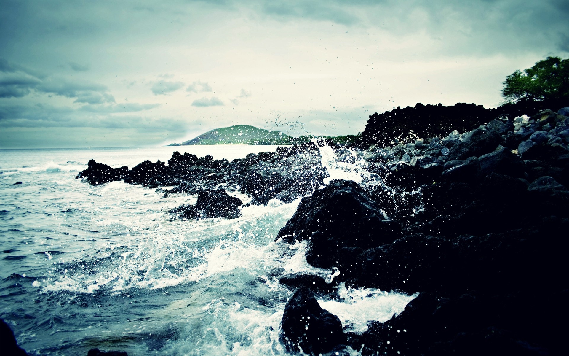 Waves crashing on dark rocks at dusk HD Wallpaper