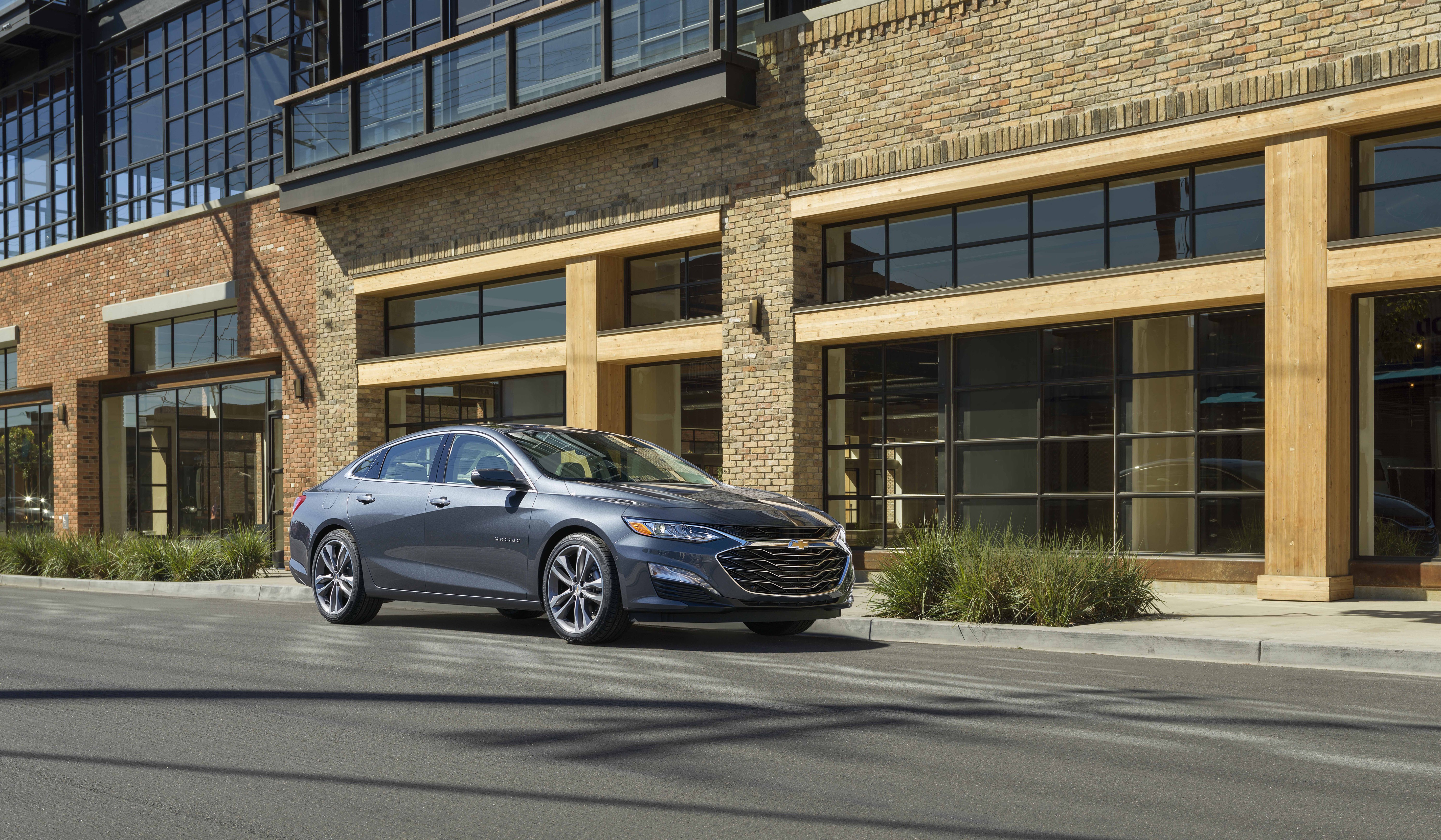 Chevrolet Malibu Electric car parked in front of a brick building HD Wallpaper