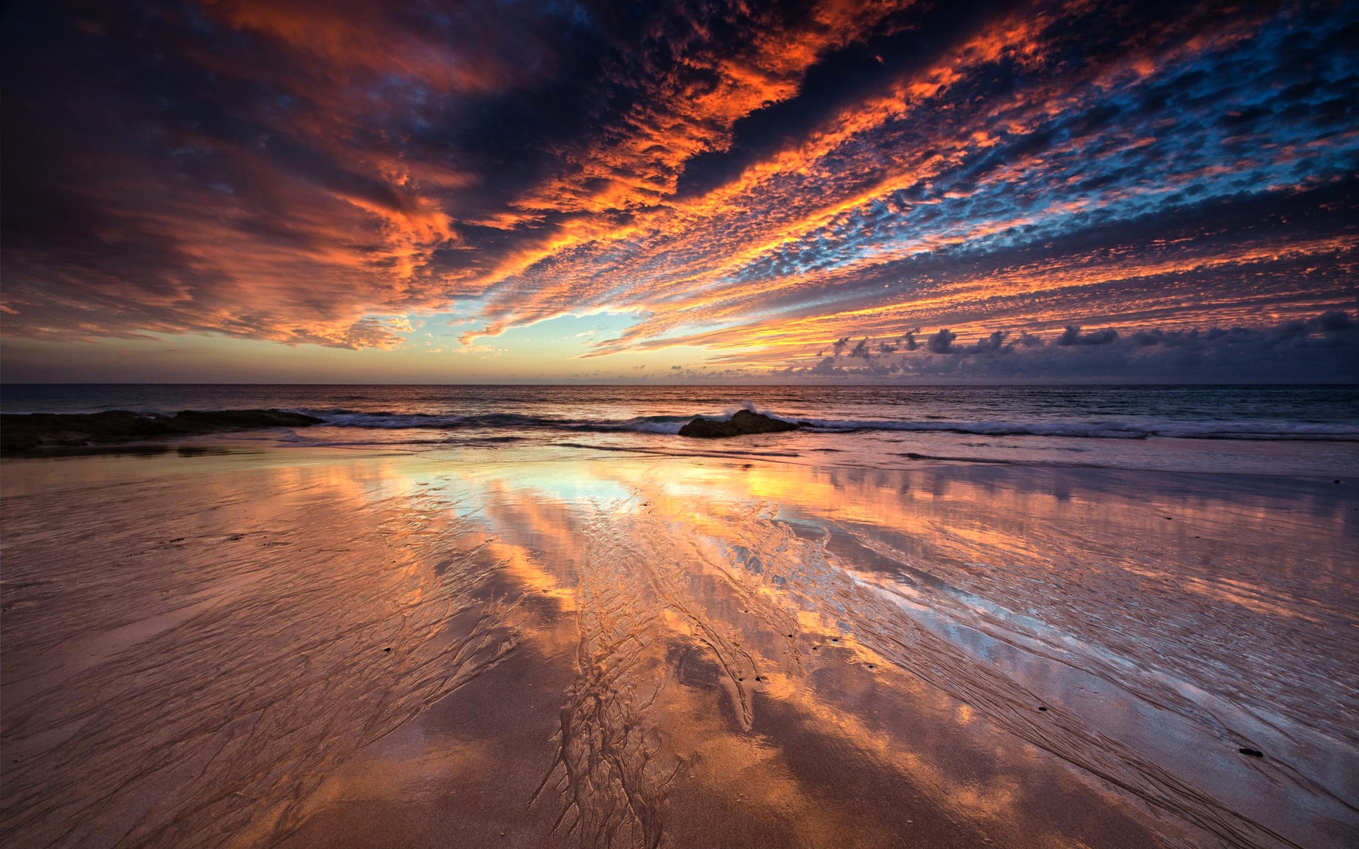 Sunset over a beach with colorful clouds and reflections HD Wallpaper