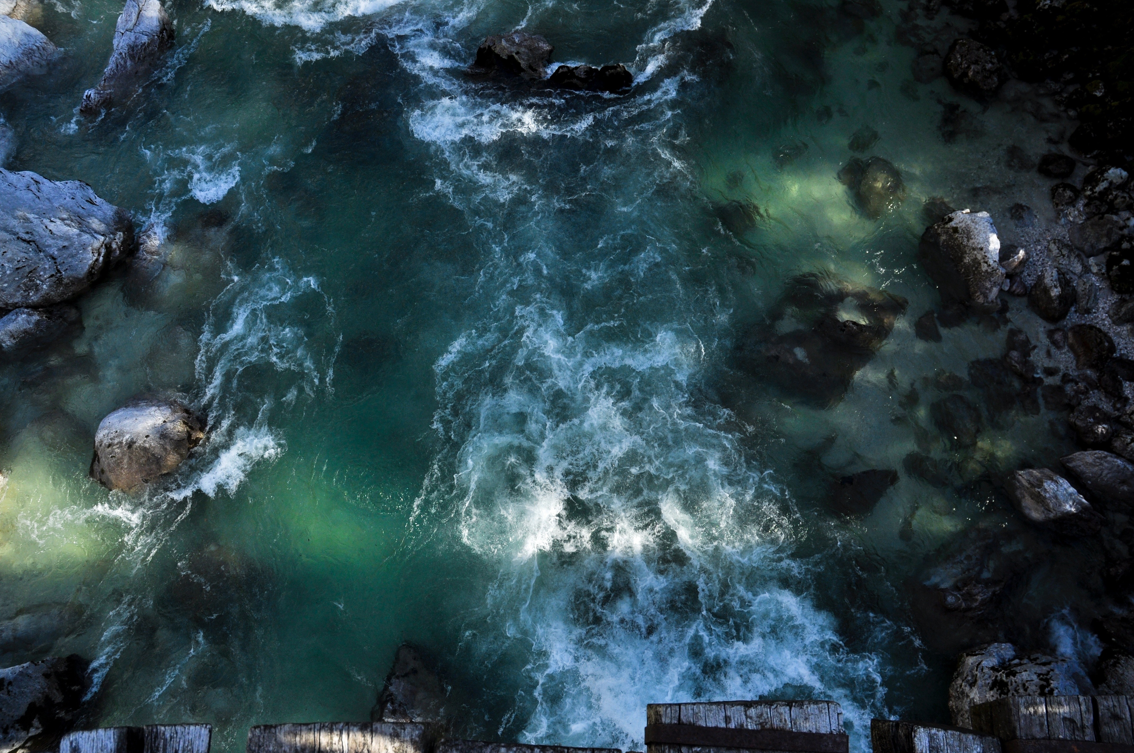 Aerial view of a turbulent river flowing over rocks HD Wallpaper