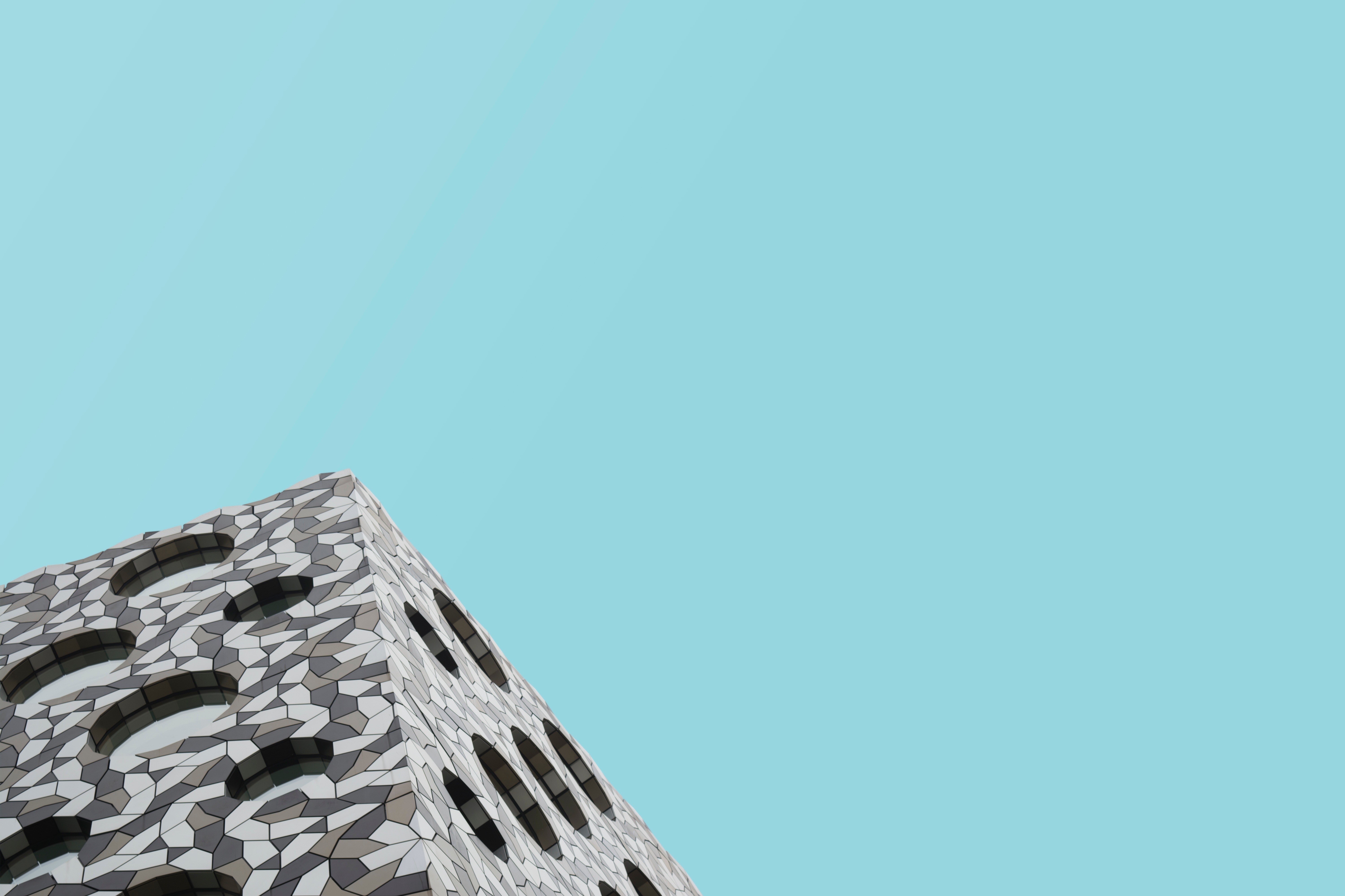 Modern building with geometric facade against clear blue sky HD Wallpaper
