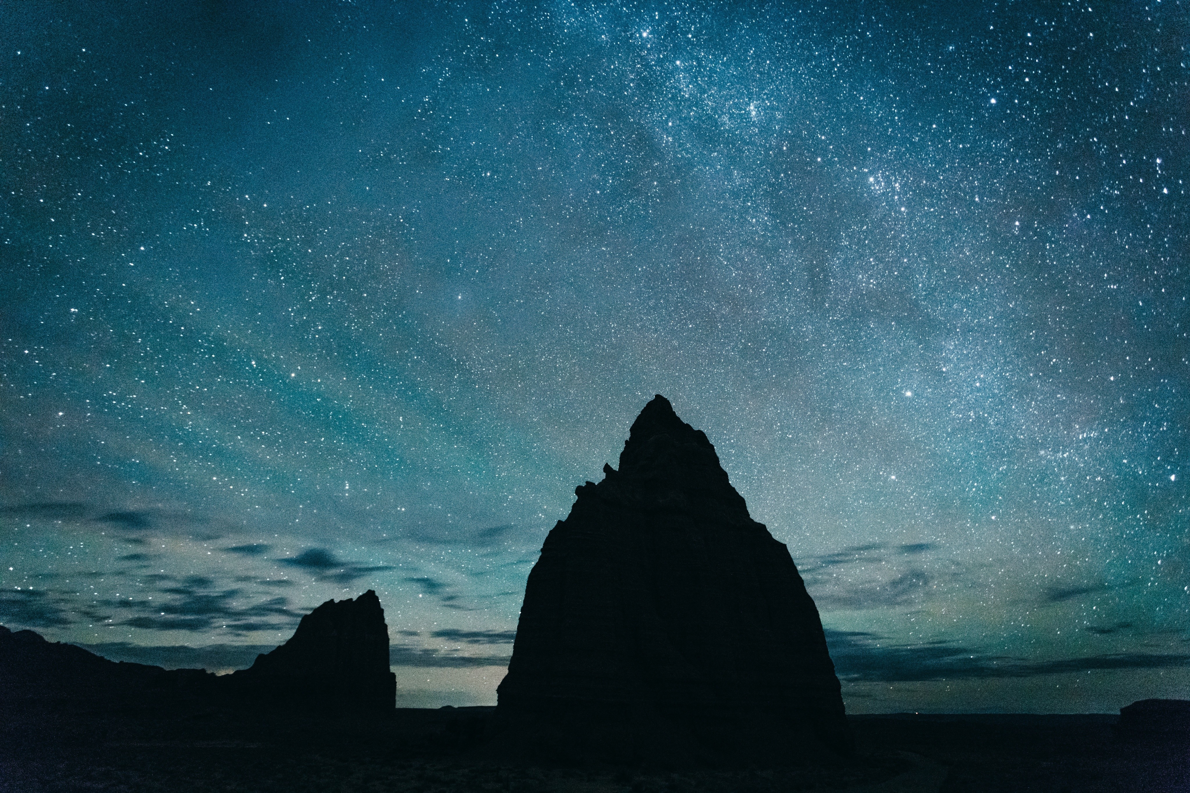Silhouette of rock formations under a starry night sky HD Wallpaper