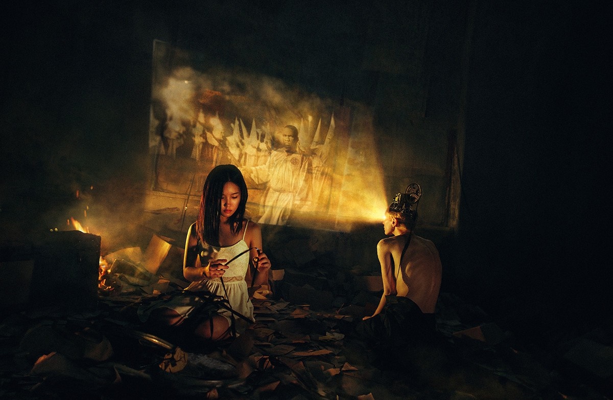Two people in a dark room with a projection HD Wallpaper