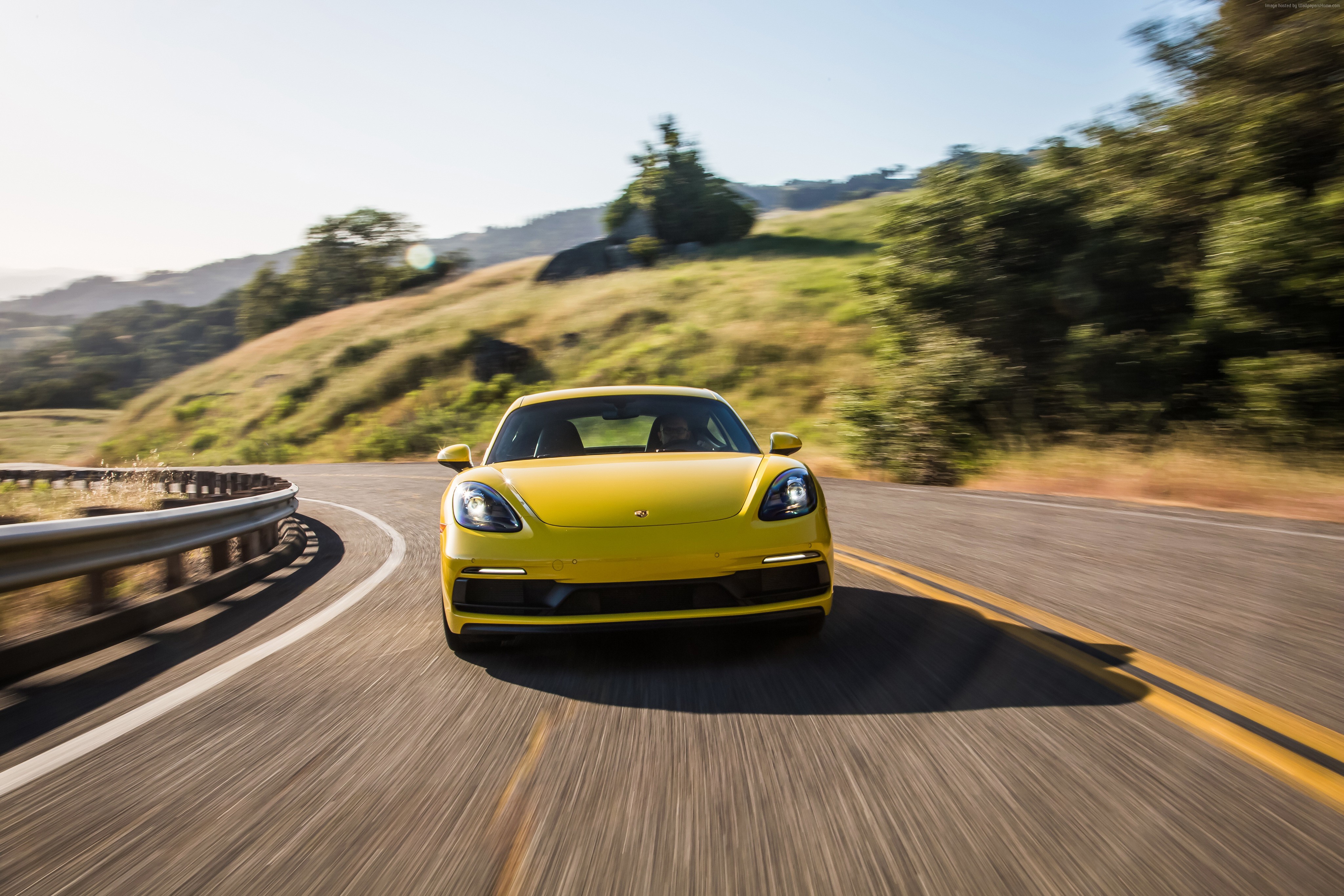 Yellow Porsche 718 Cayman GTS driving on a winding road HD Wallpaper