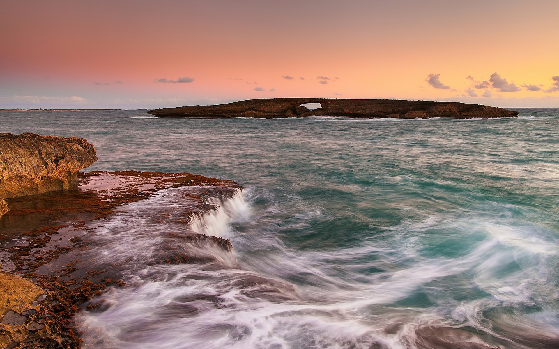 Ocean waves crashing on rocky shore at sunset HD Wallpaper