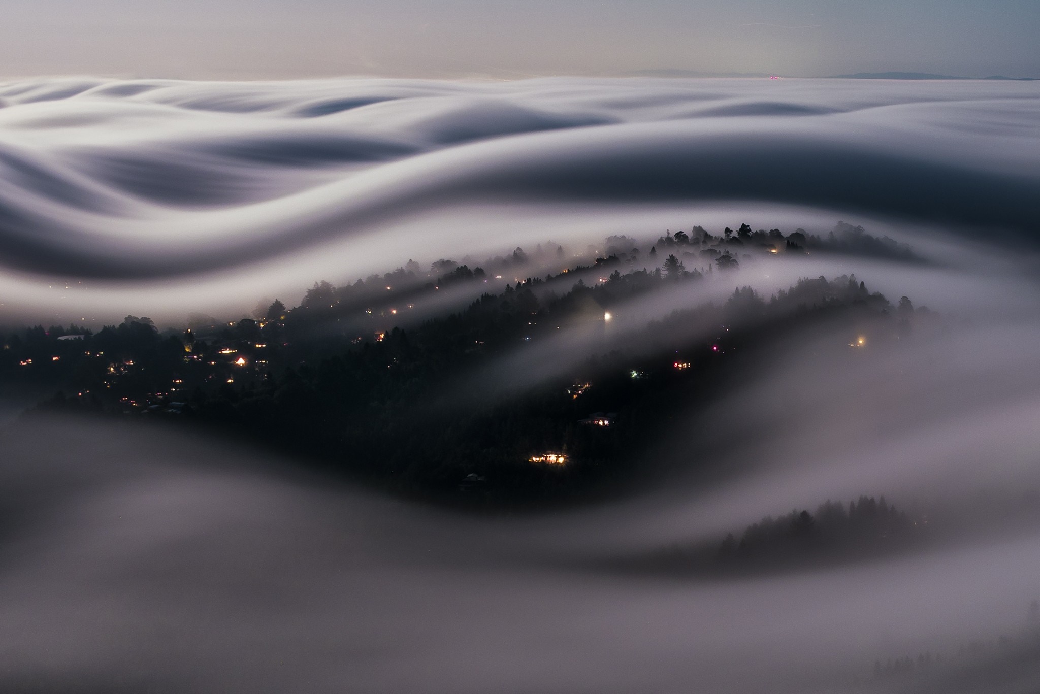 Fog rolling over a town at night HD Wallpaper