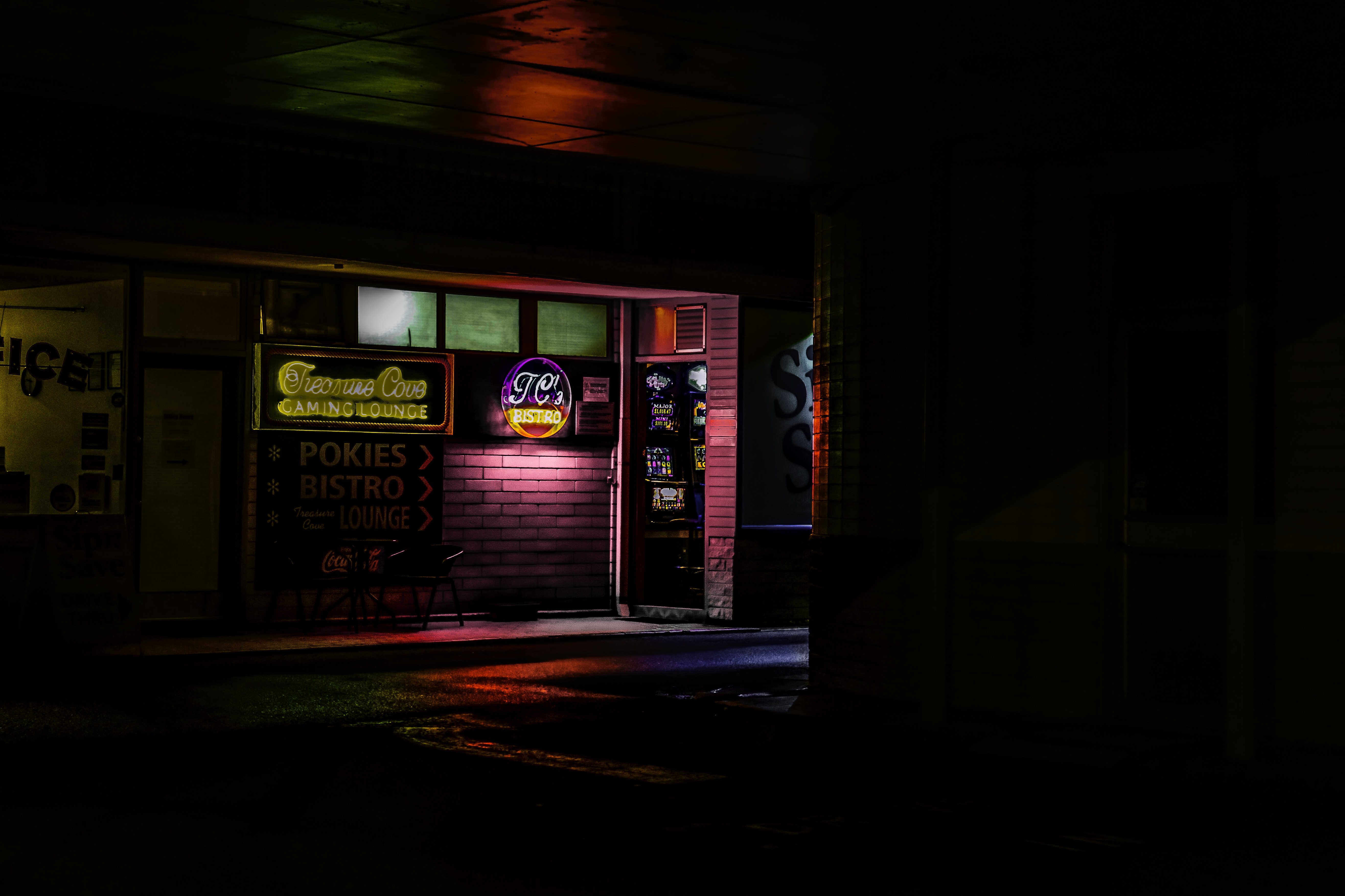 Neon signs for Treasure Cove Gaming Lounge and TC's Bistro at night HD Wallpaper