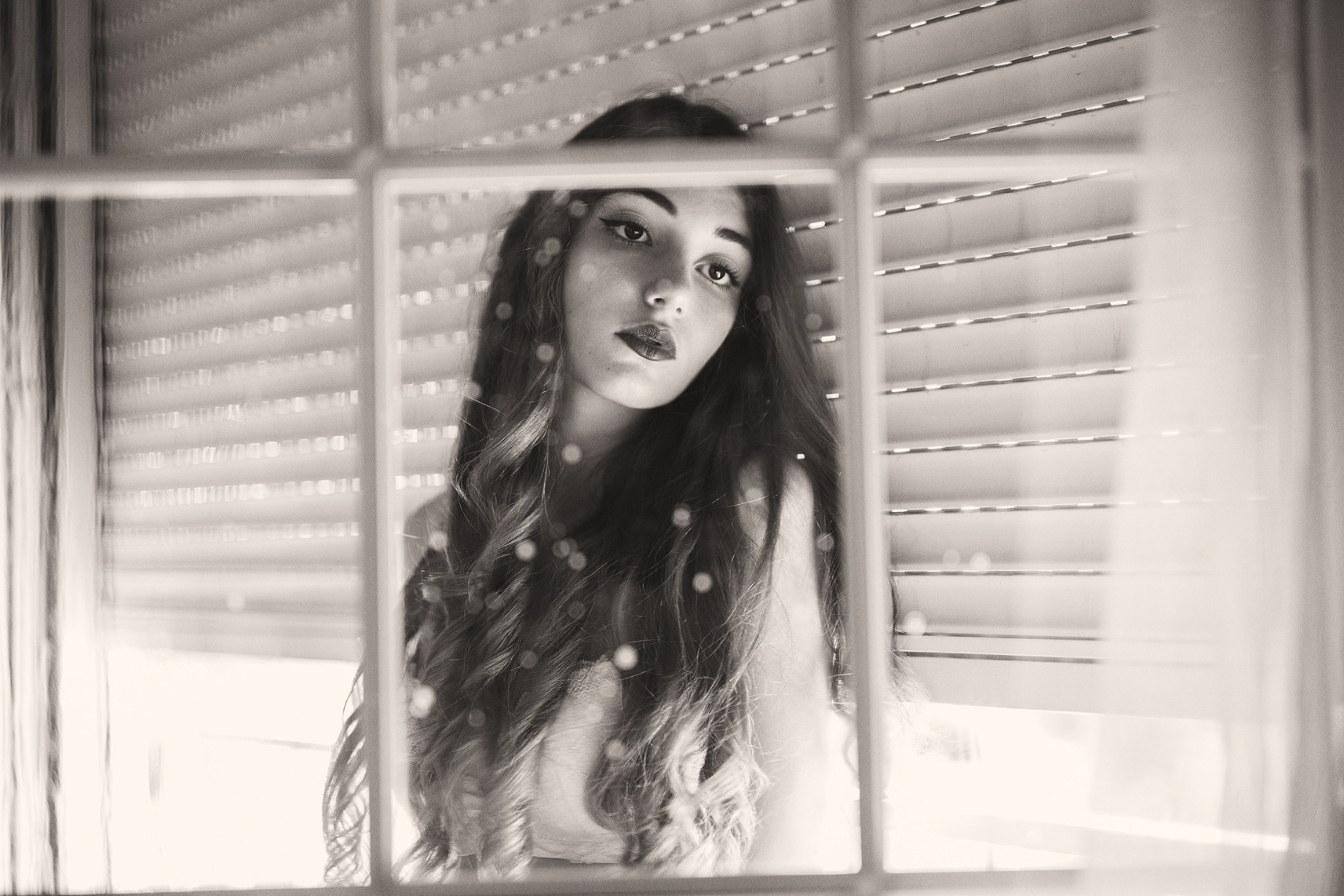 Monochrome portrait of a woman behind a window HD Wallpaper