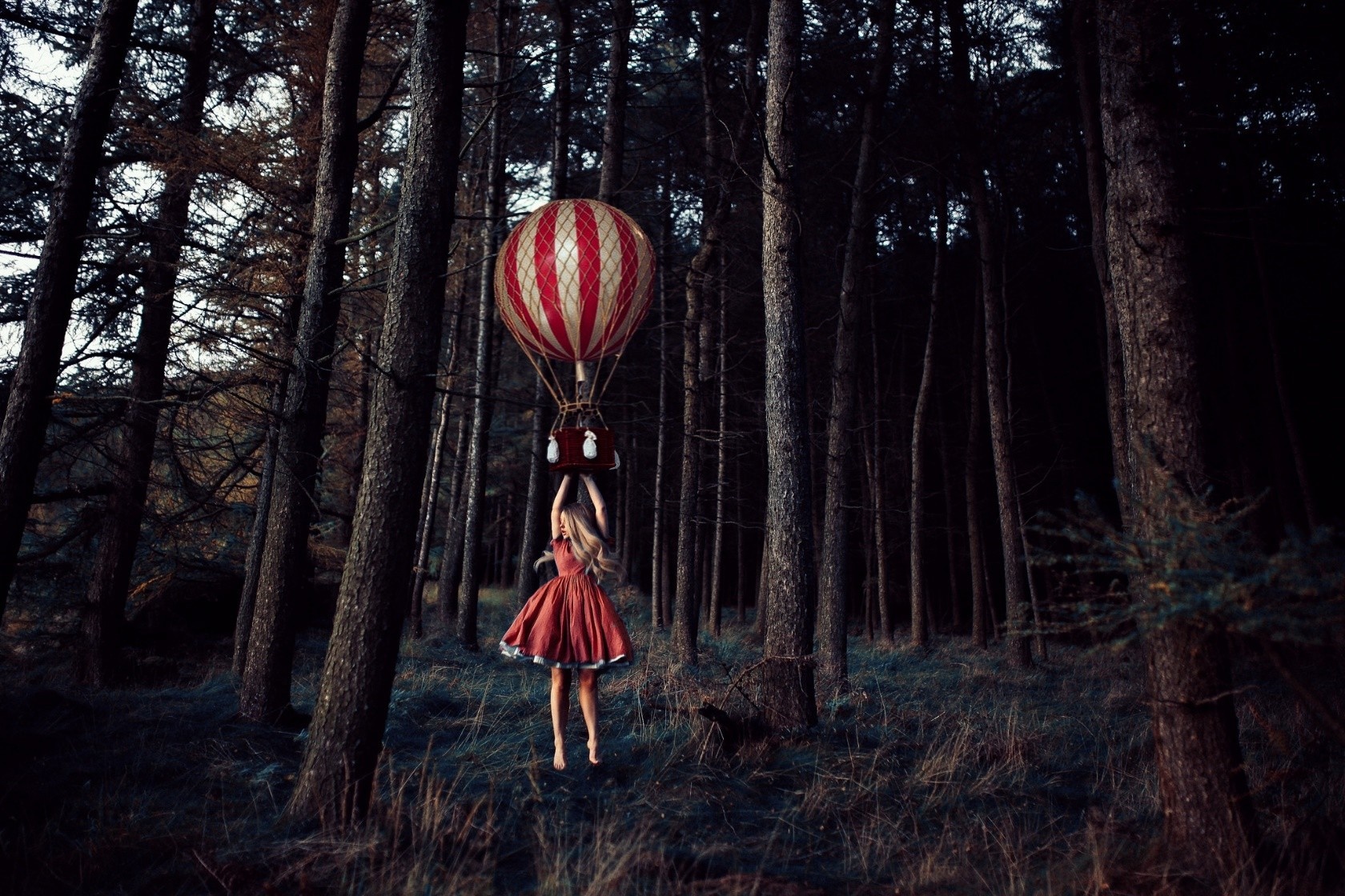 Girl in red dress holding a hot air balloon in a dark forest HD Wallpaper