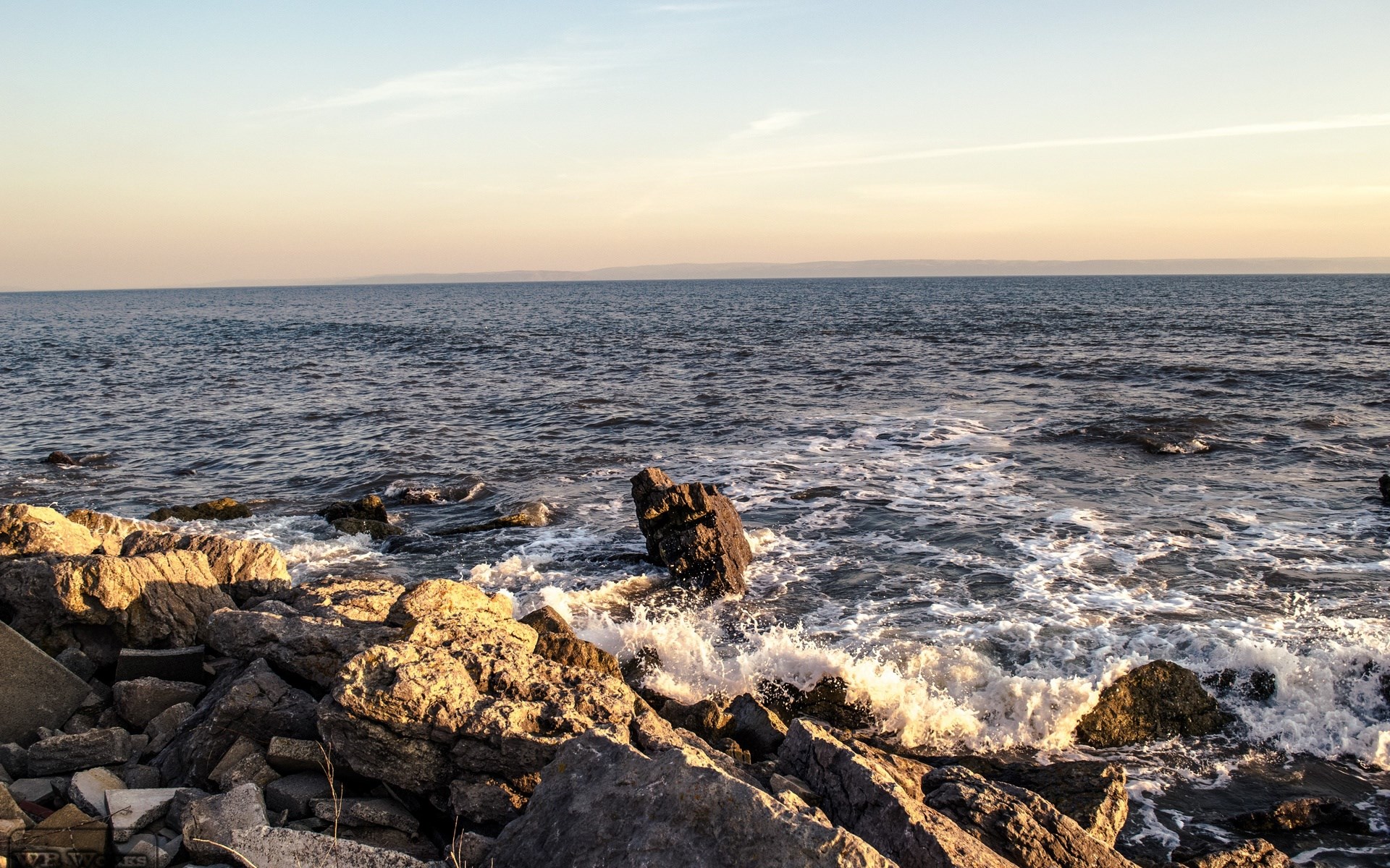 Waves crashing on a rocky shore at sunset HD Wallpaper