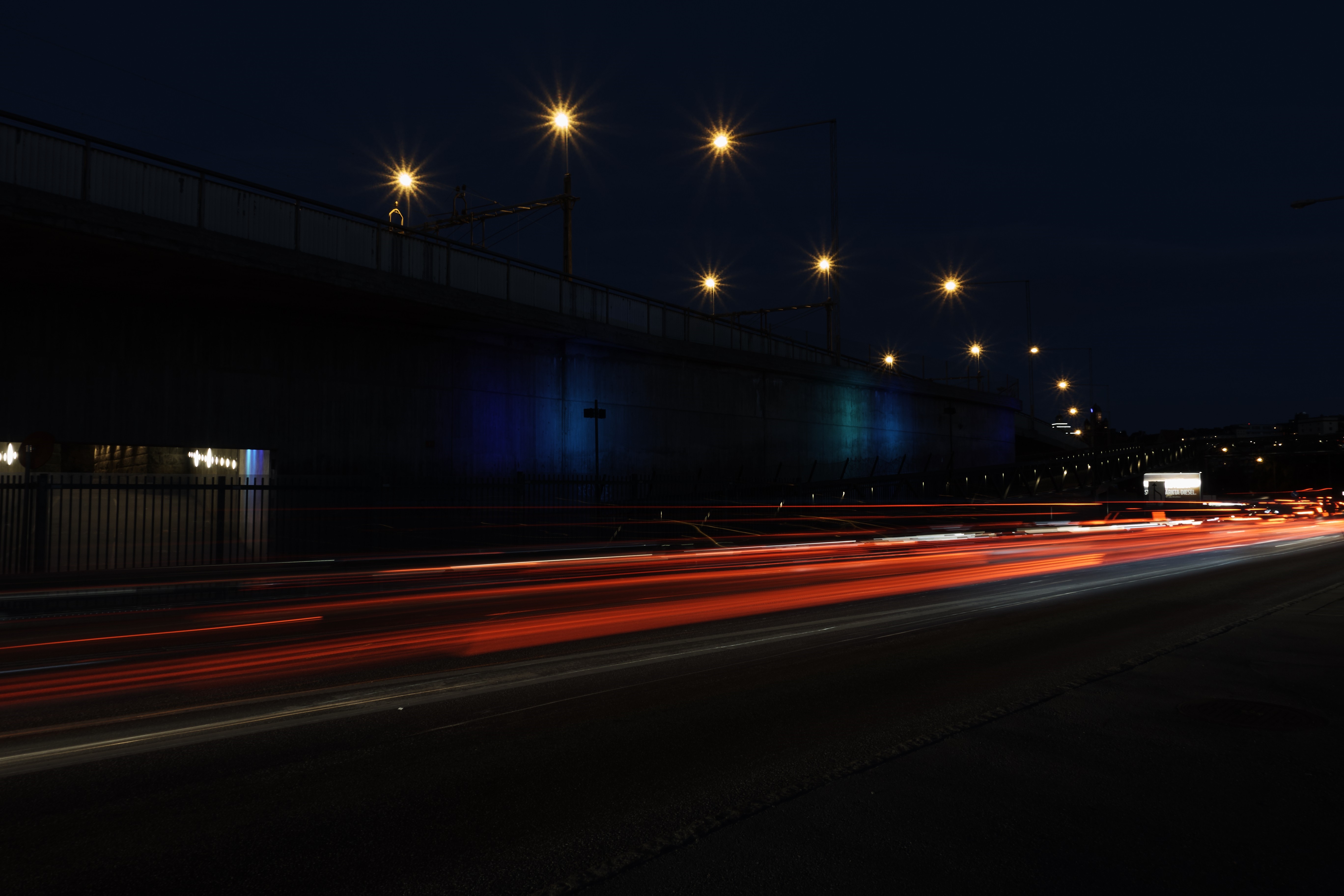Night highway with light trails under a bridge HD Wallpaper