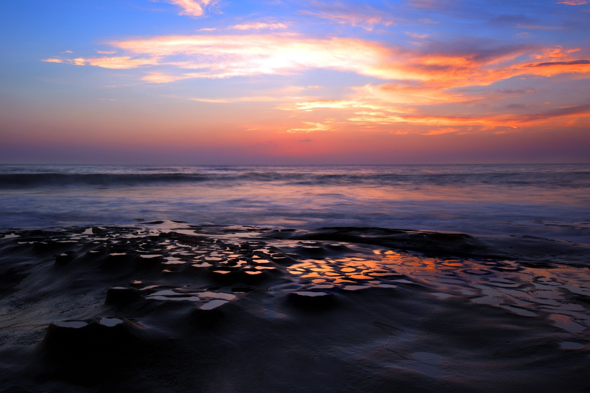 Sunset over the ocean with rocky shore HD Wallpaper