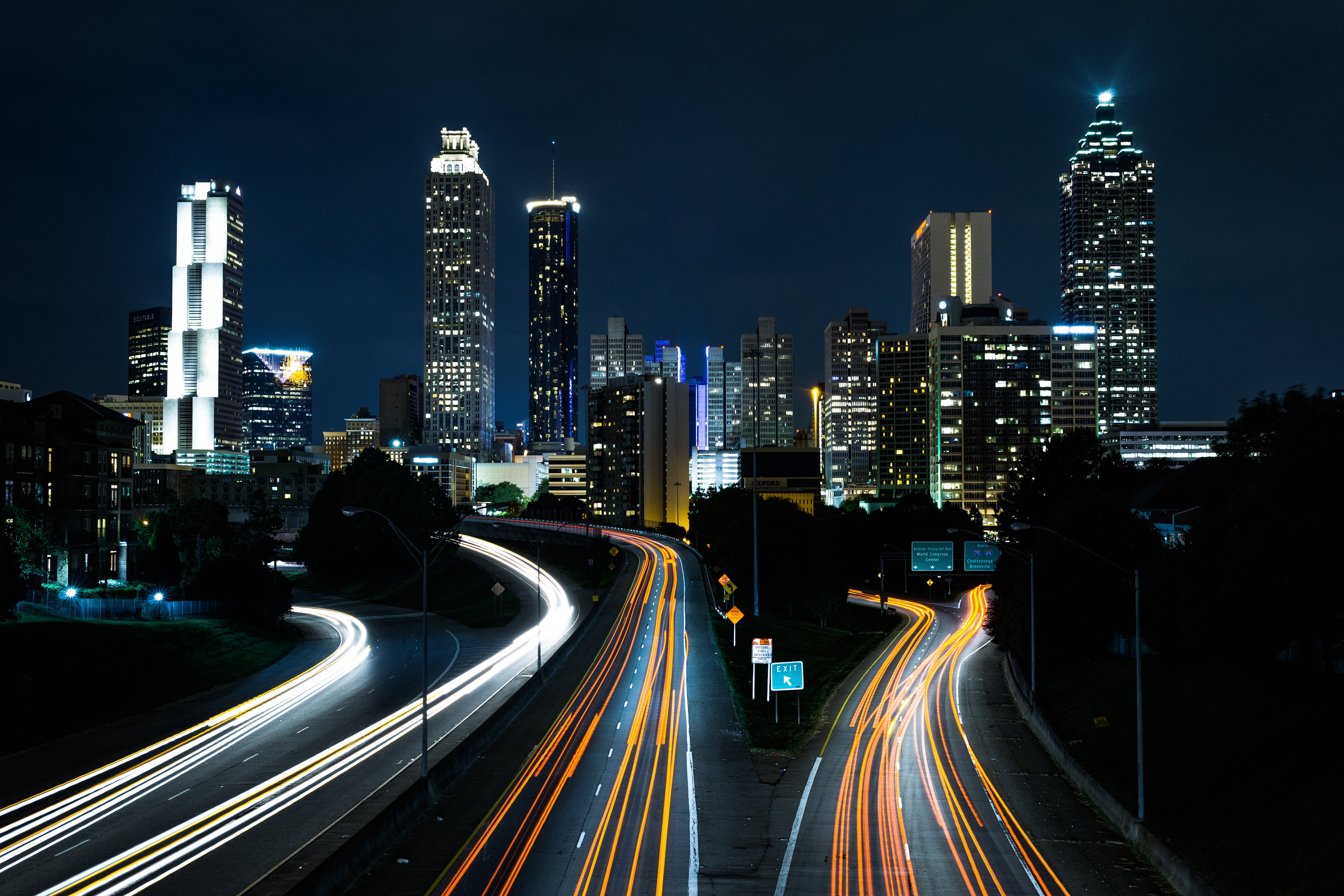 Cityscape at night with light trails on highways HD Wallpaper