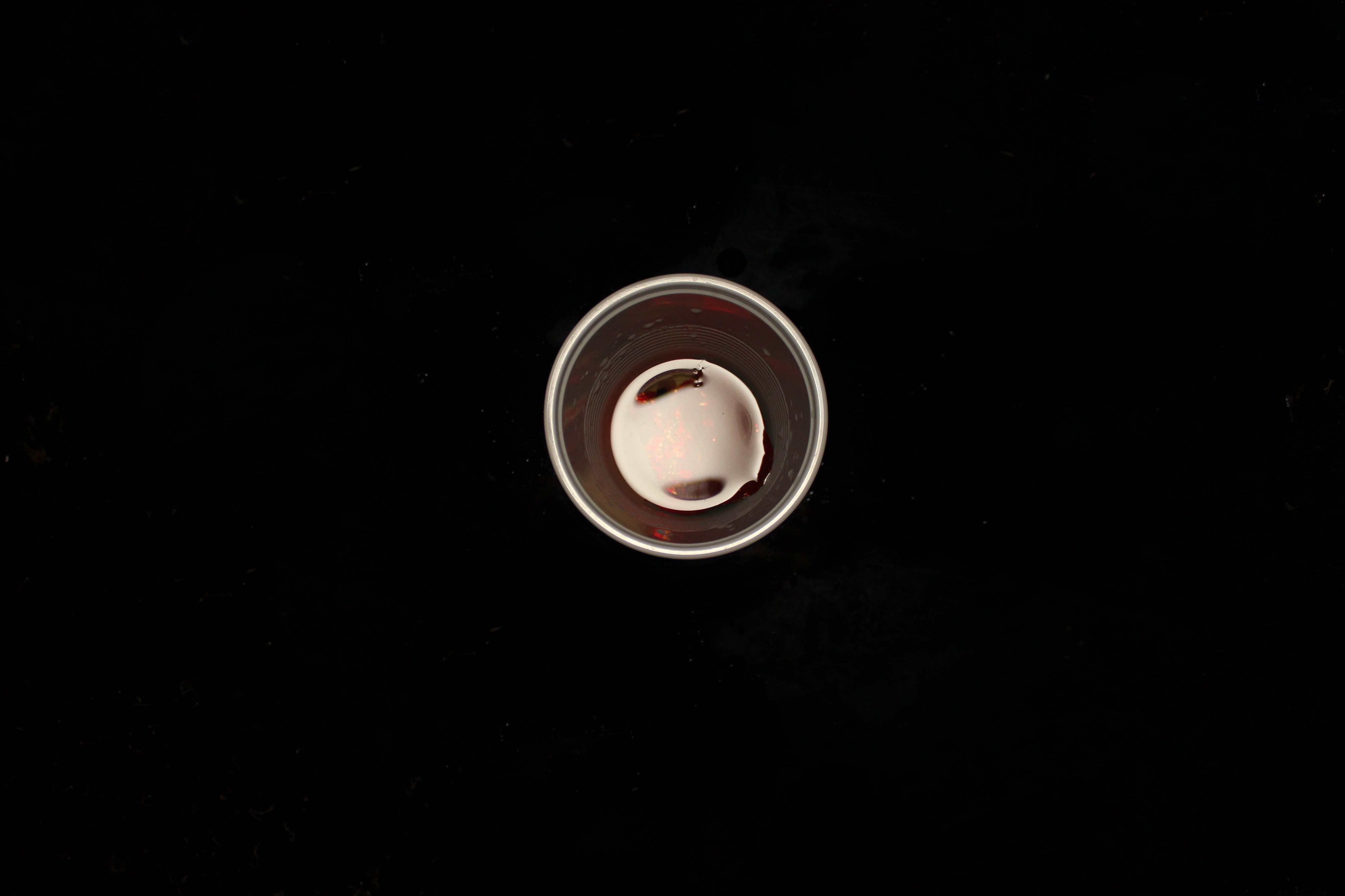A small cup with red liquid and reflections HD Wallpaper