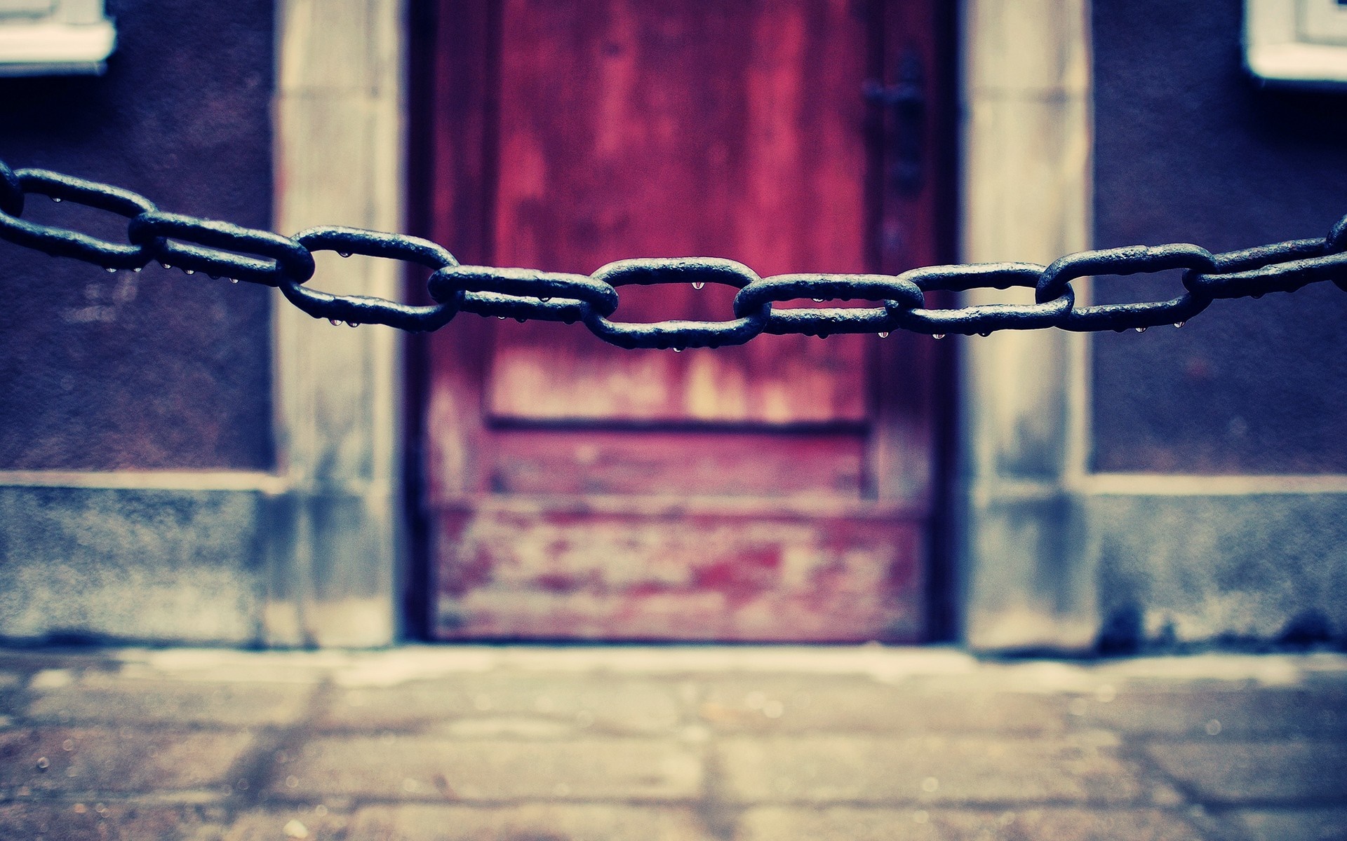 Close-up of a wet chain in front of a red door HD Wallpaper