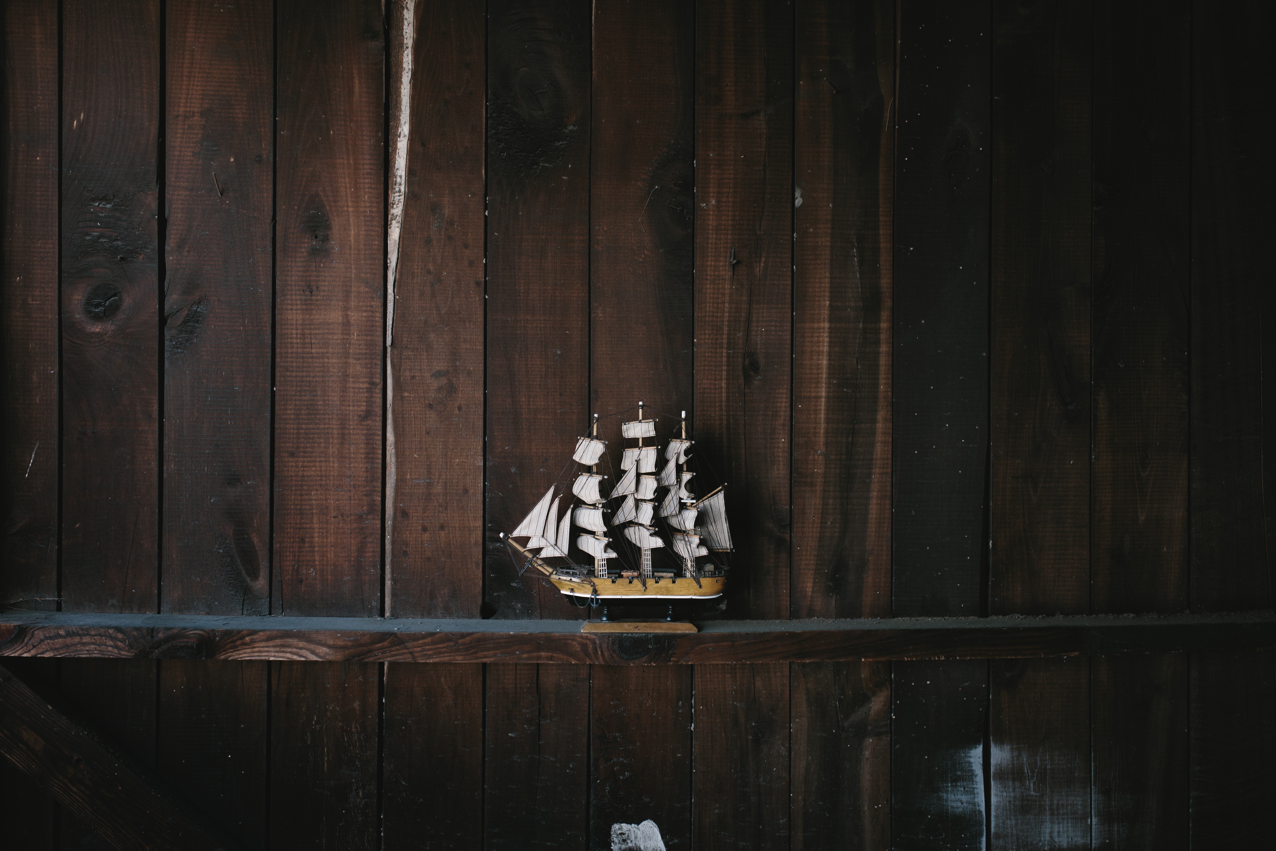 Model sailboat on a wooden shelf HD Wallpaper