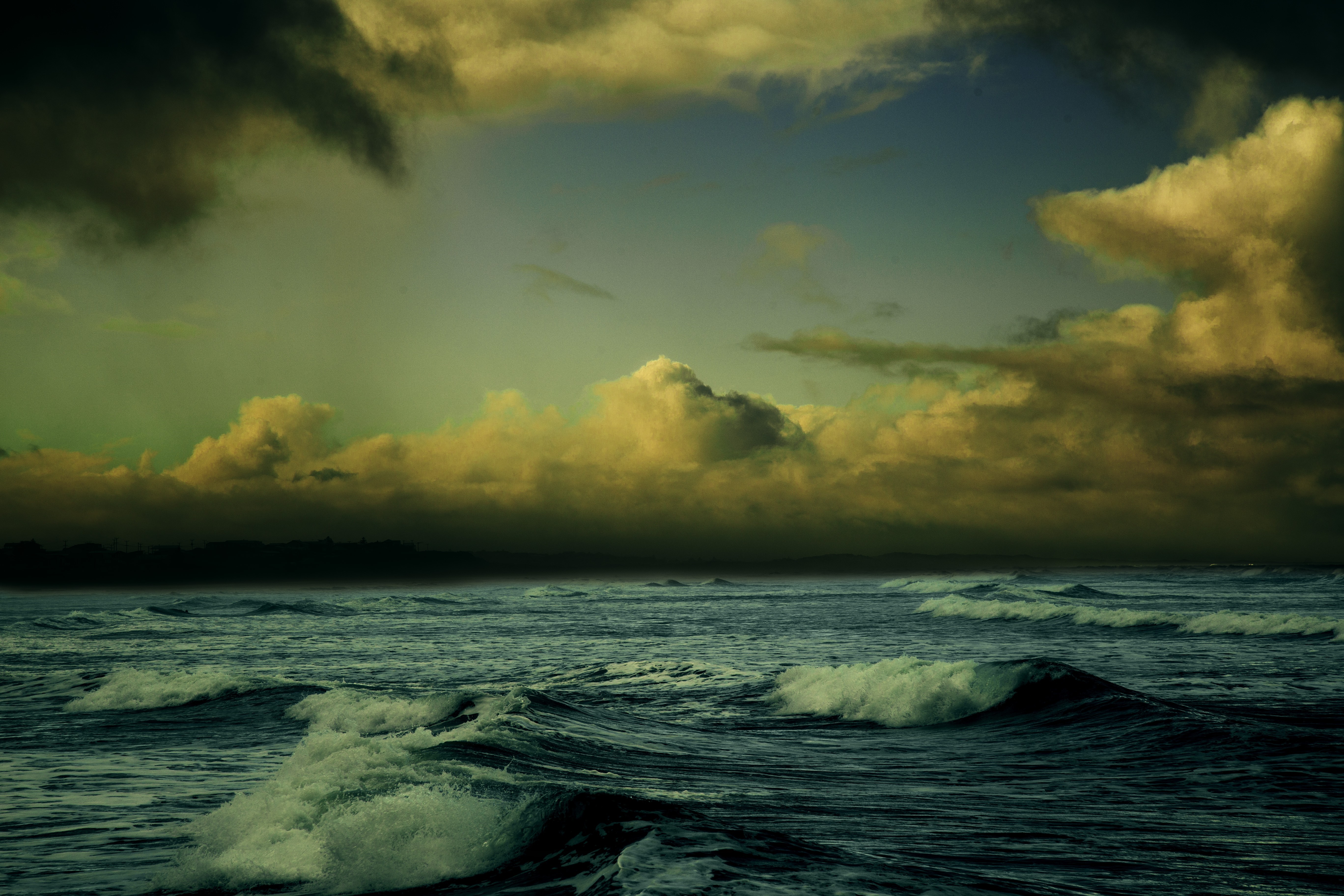 Waves crashing on the shore under a dramatic sky HD Wallpaper