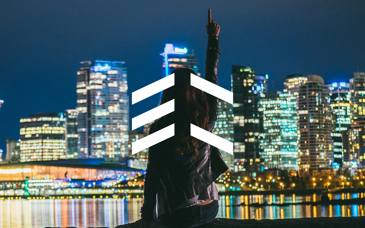 Woman pointing up in front of city skyline at night HD Wallpaper