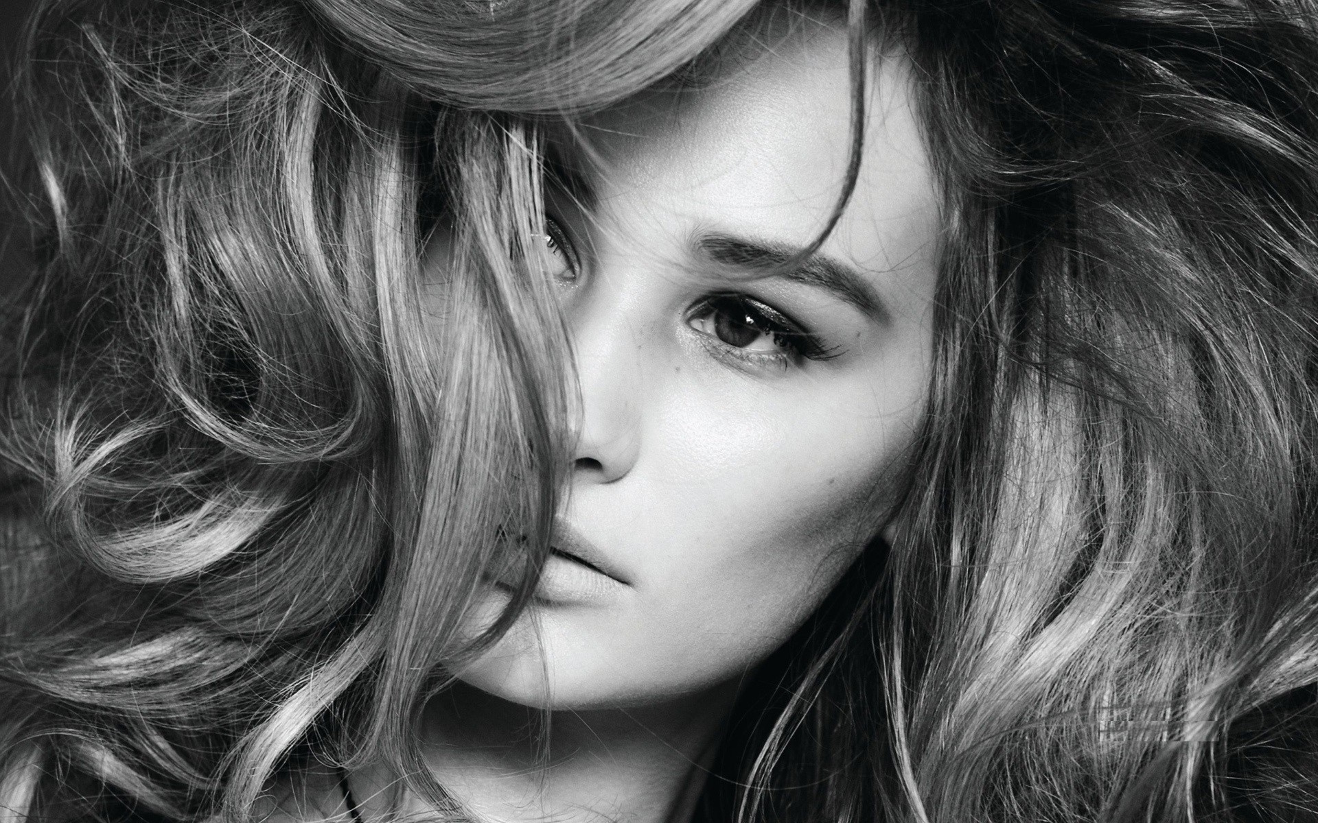 Monochrome portrait of a woman with long, wavy hair HD Wallpaper