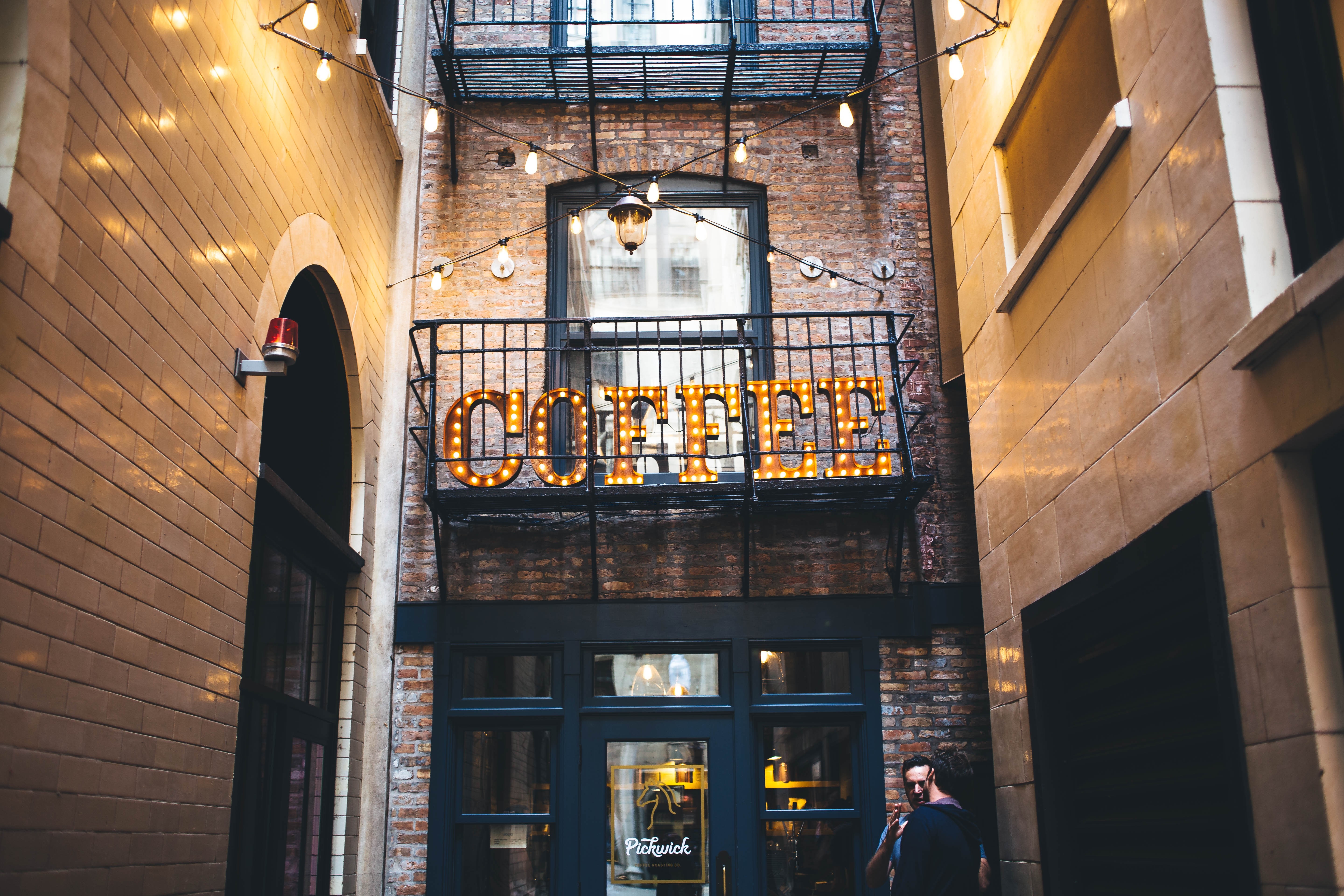 Coffee shop sign with lights in an alley HD Wallpaper