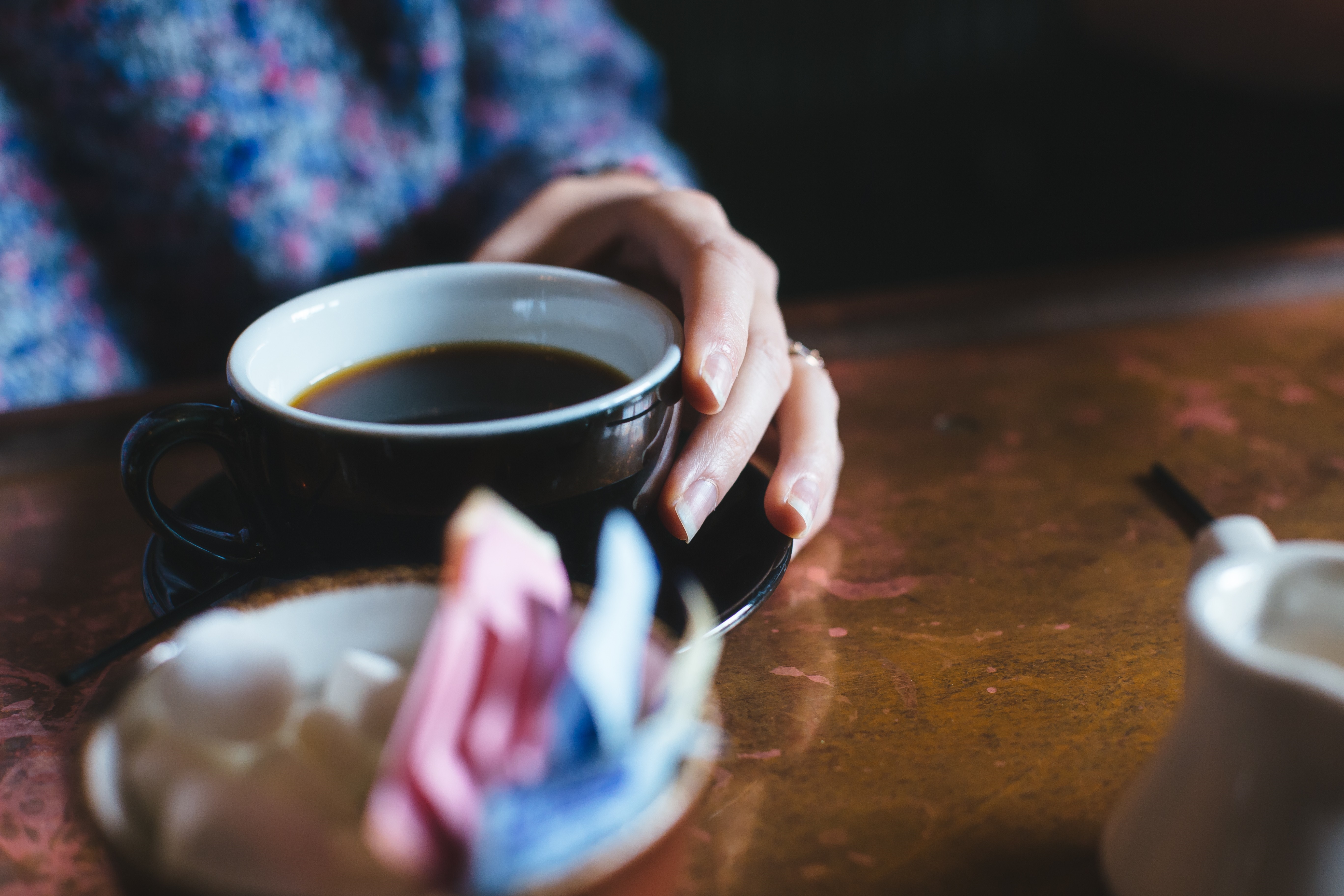 Person holding a cup of coffee with sugar cubes HD Wallpaper