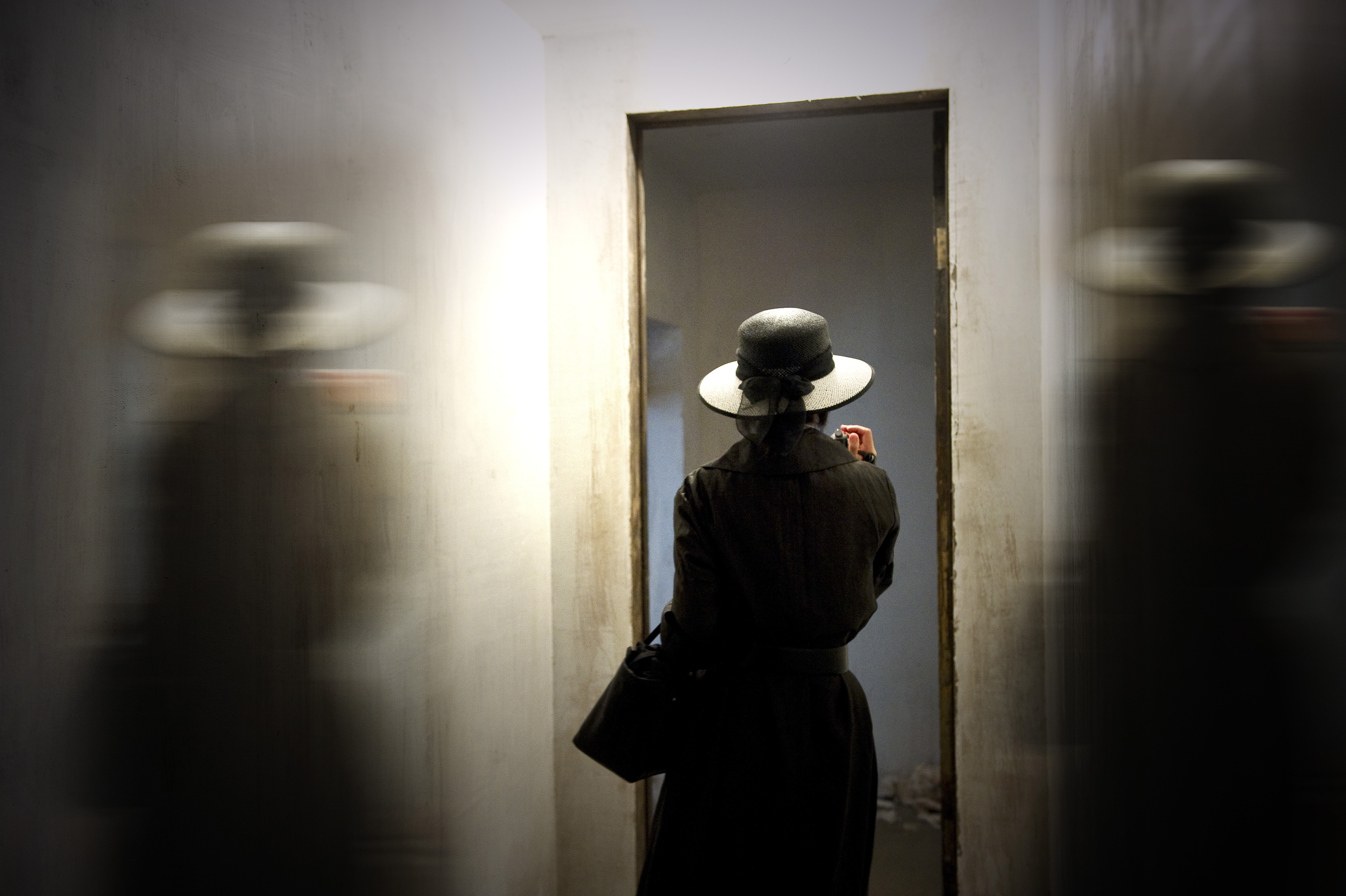 Woman in hat and coat in doorway with motion blur HD Wallpaper