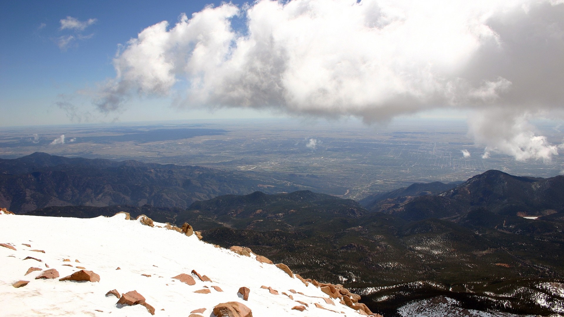 Snowy mountain peak overlooking a vast valley and clouds HD Wallpaper