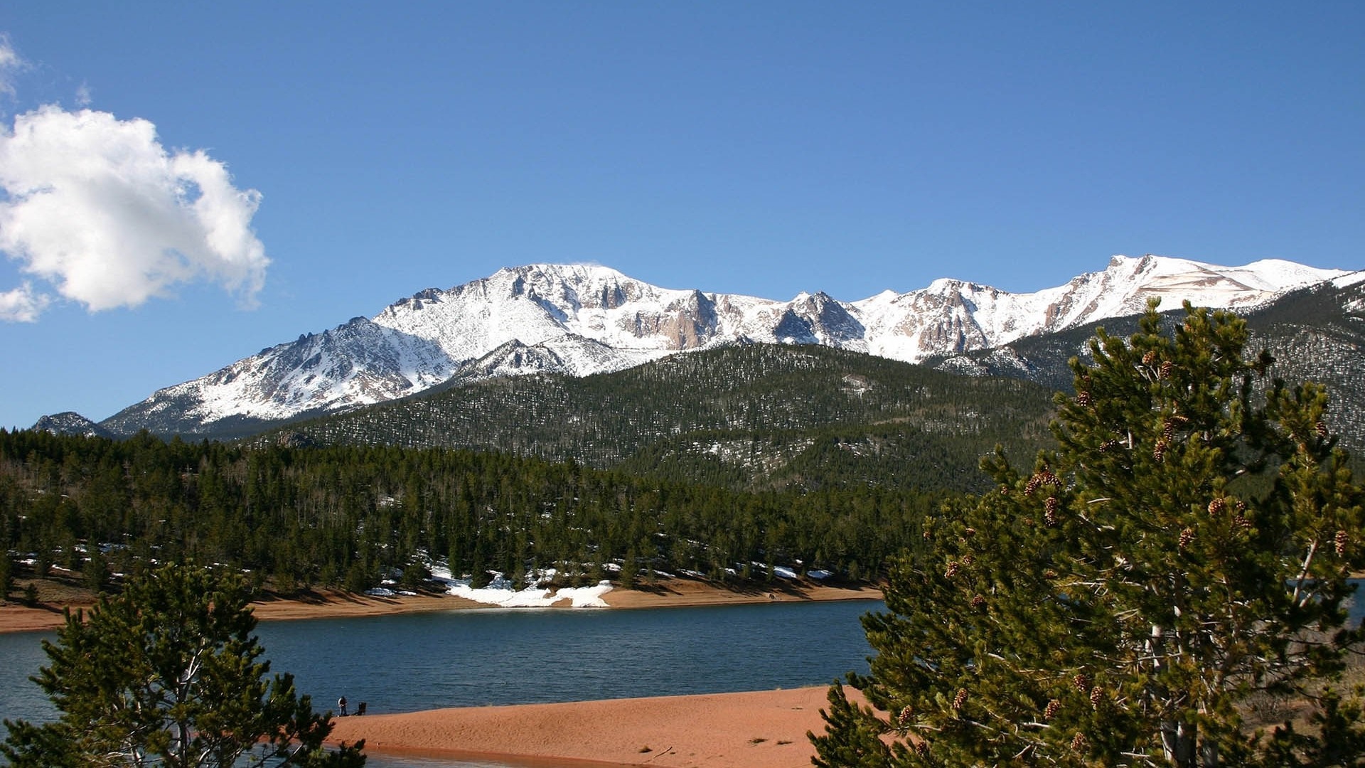 Snow-capped mountains overlooking a lake and forest HD Wallpaper