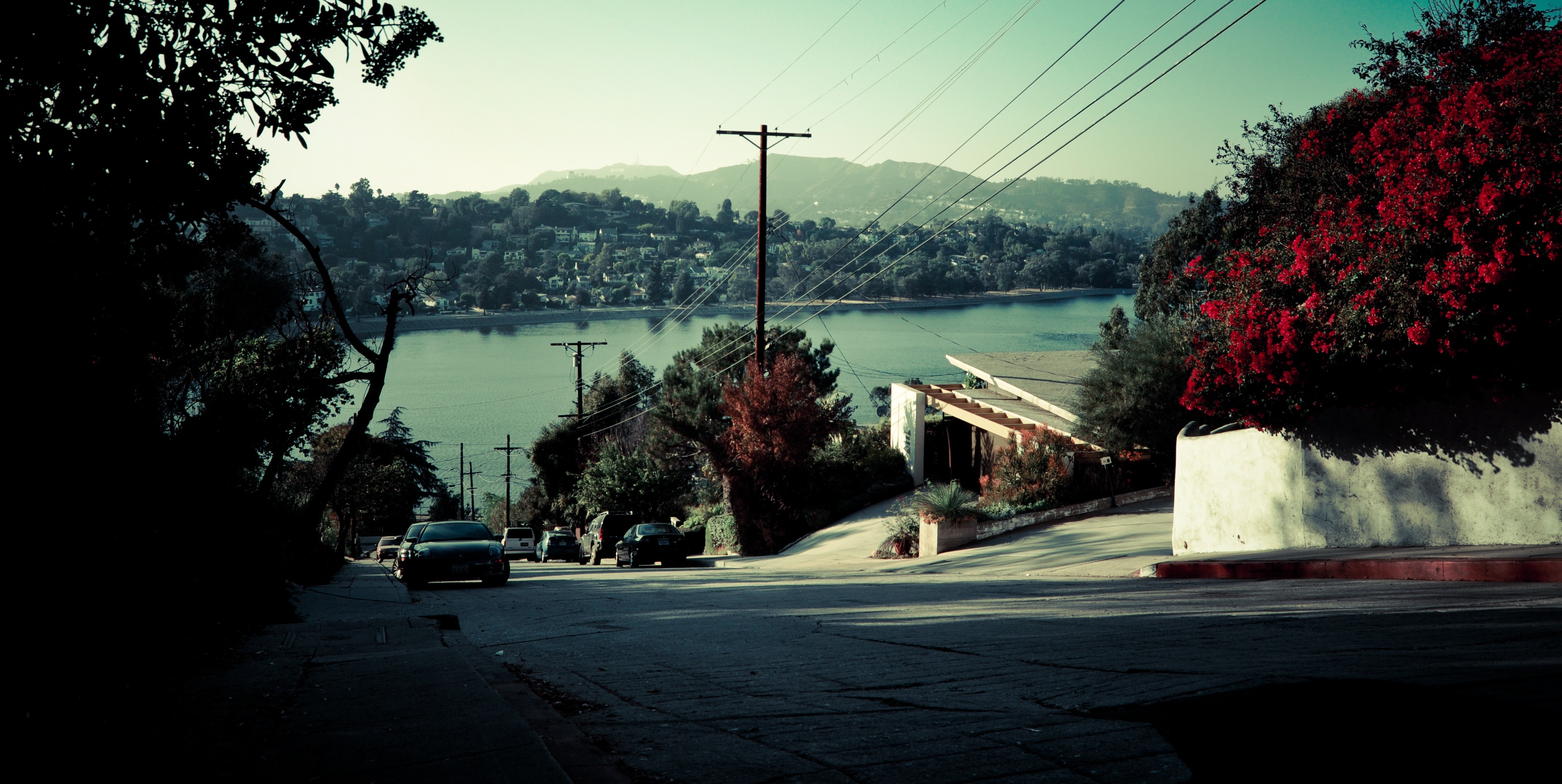Street overlooking a lake with houses and mountains HD Wallpaper