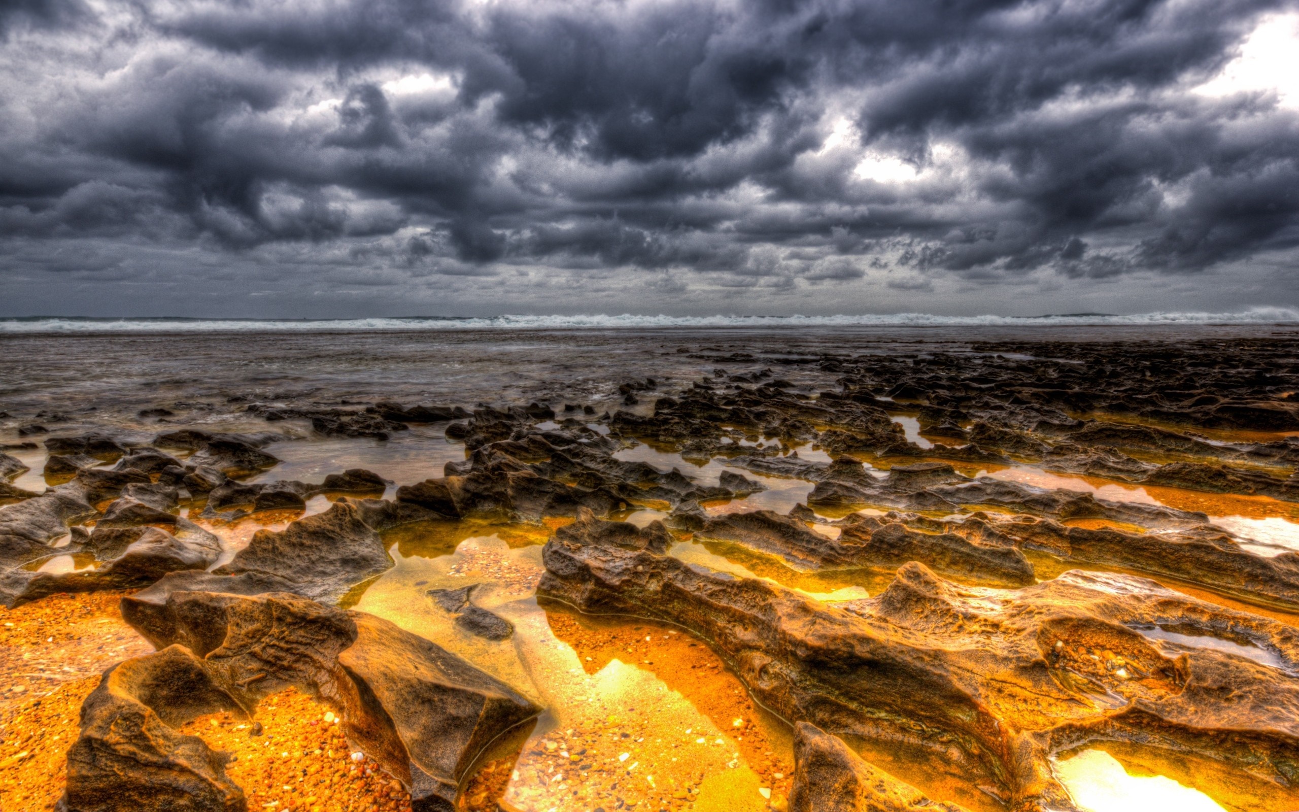 Rocky Shoreline Under Stormy Clouds HD Wallpaper