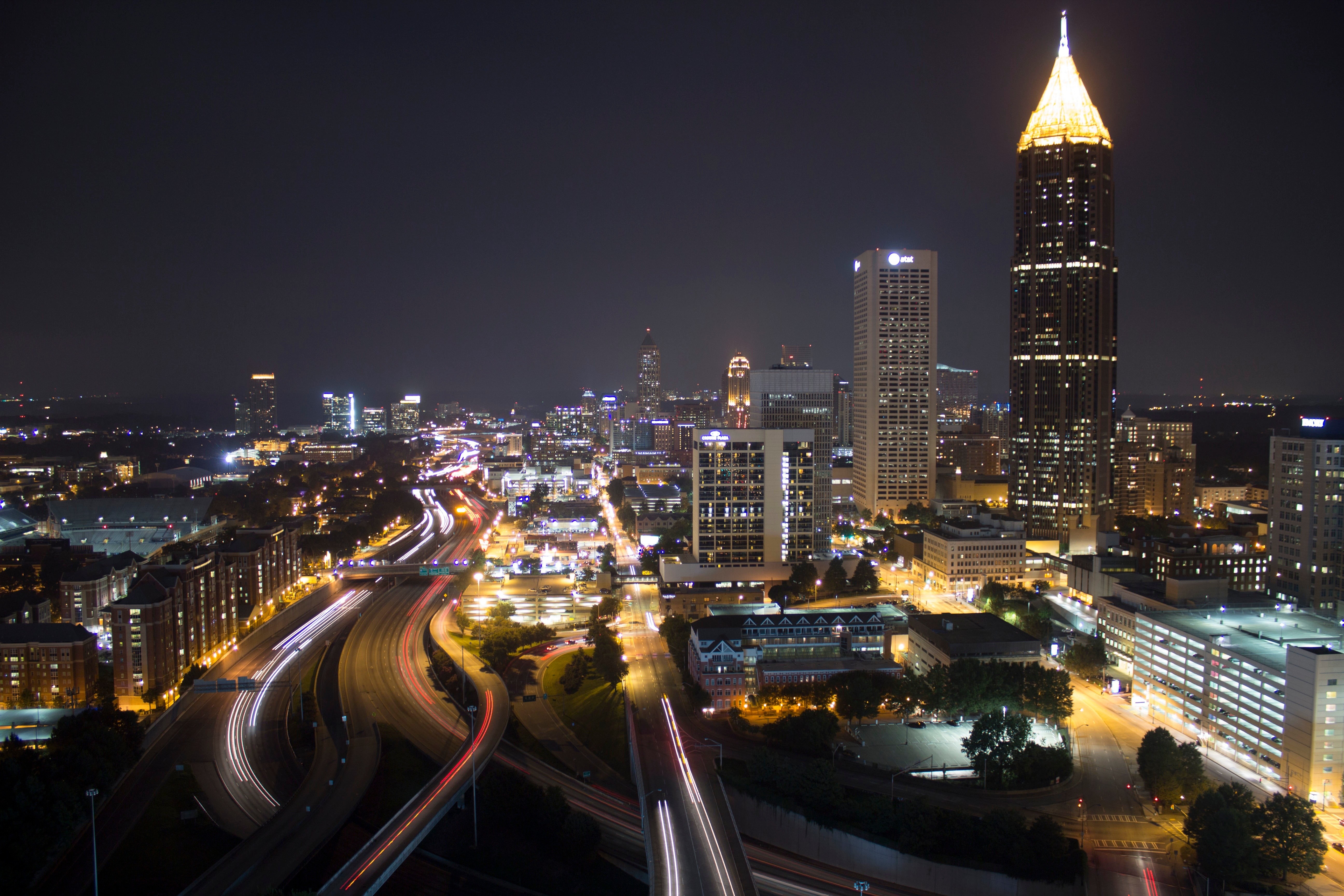 Atlanta cityscape at night with illuminated skyscrapers and highways HD Wallpaper