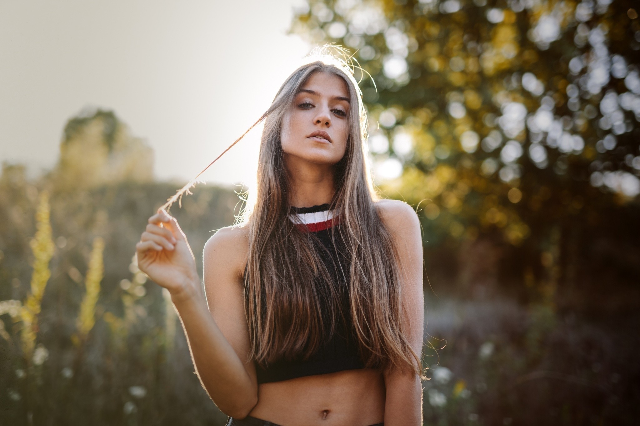 Woman with long brown hair in a black crop top outdoors HD Wallpaper