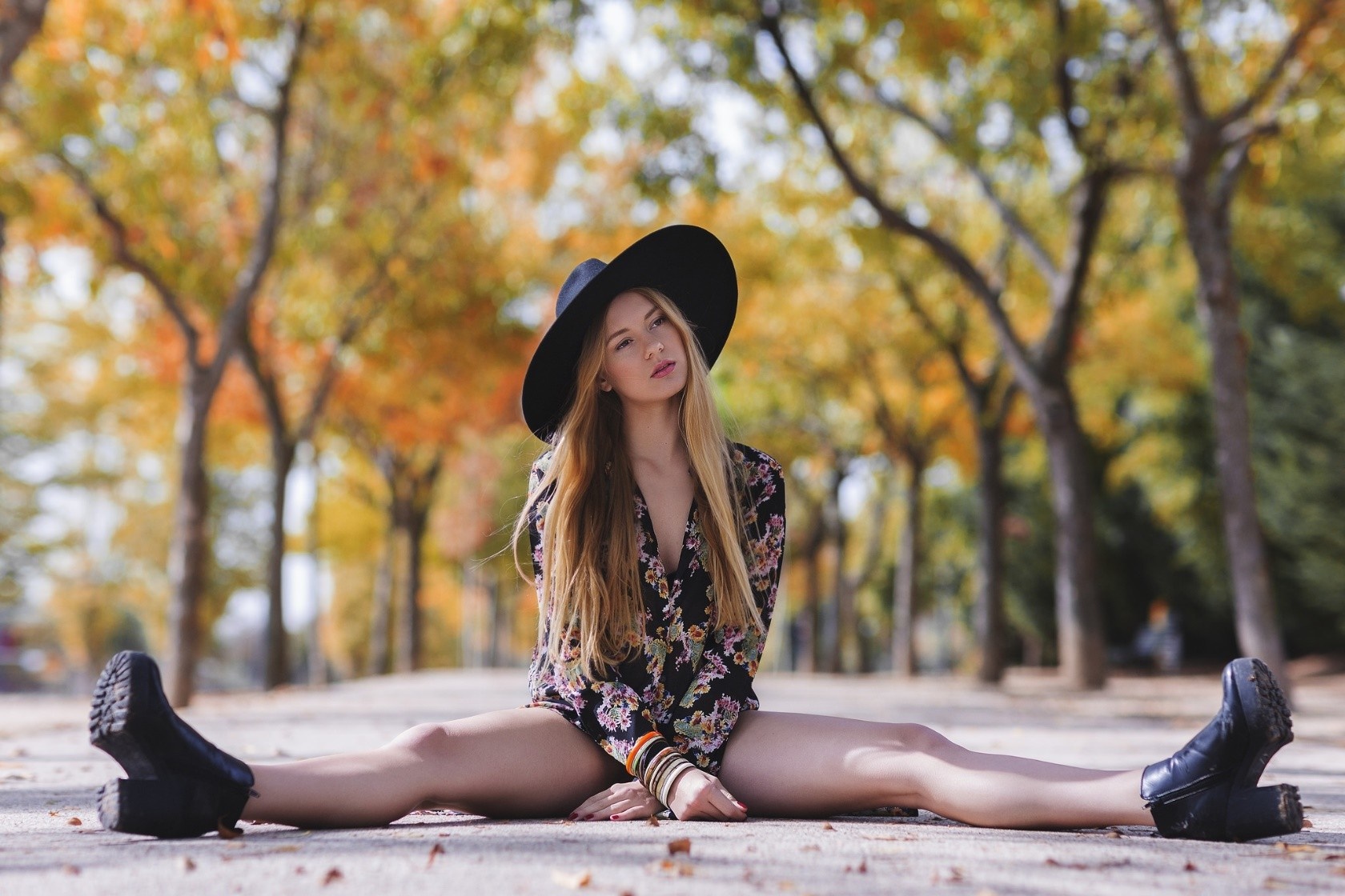 Woman in hat and floral dress sitting on ground HD Wallpaper