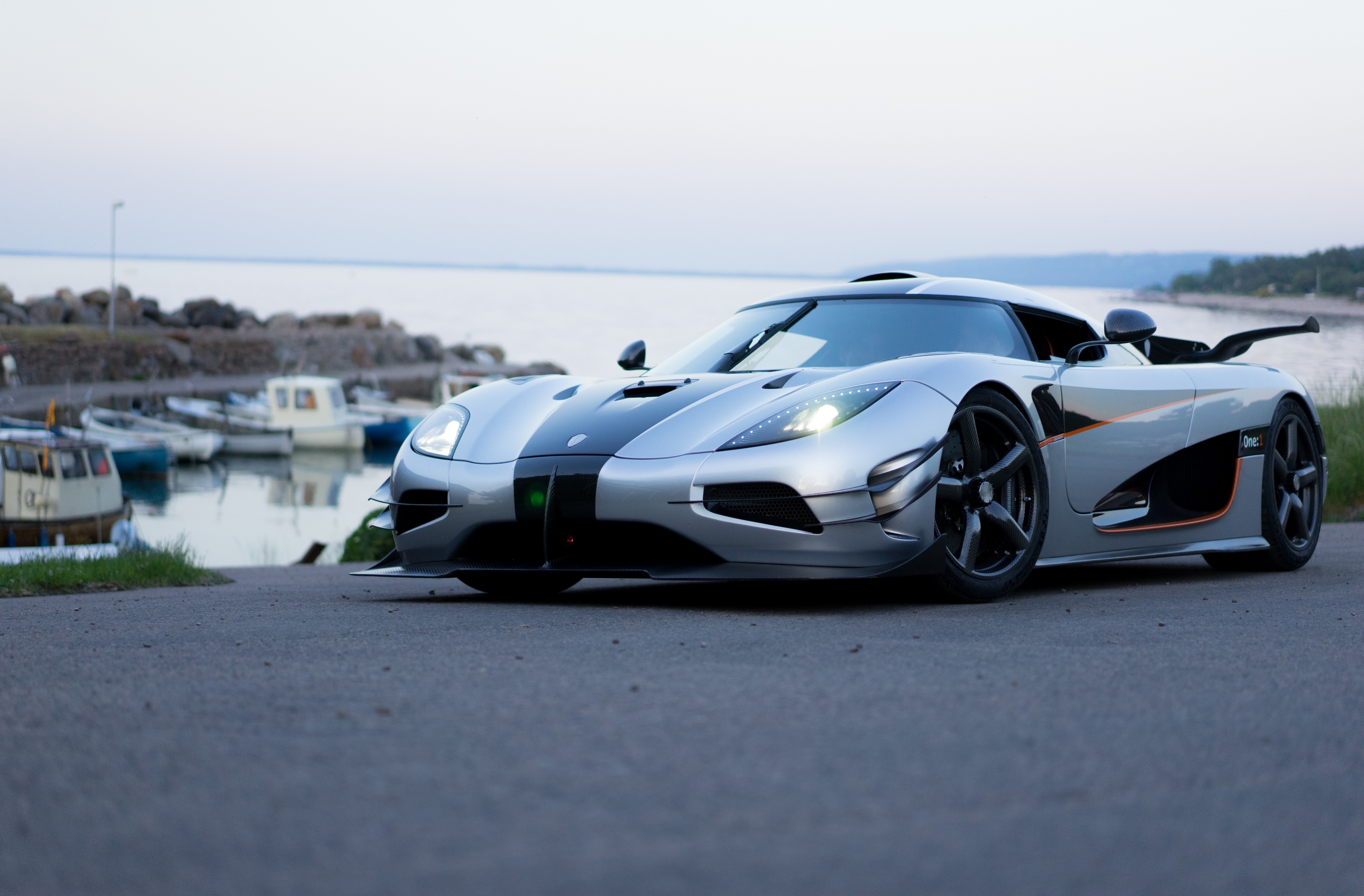 Silver Koenigsegg sports car by a harbor HD Wallpaper