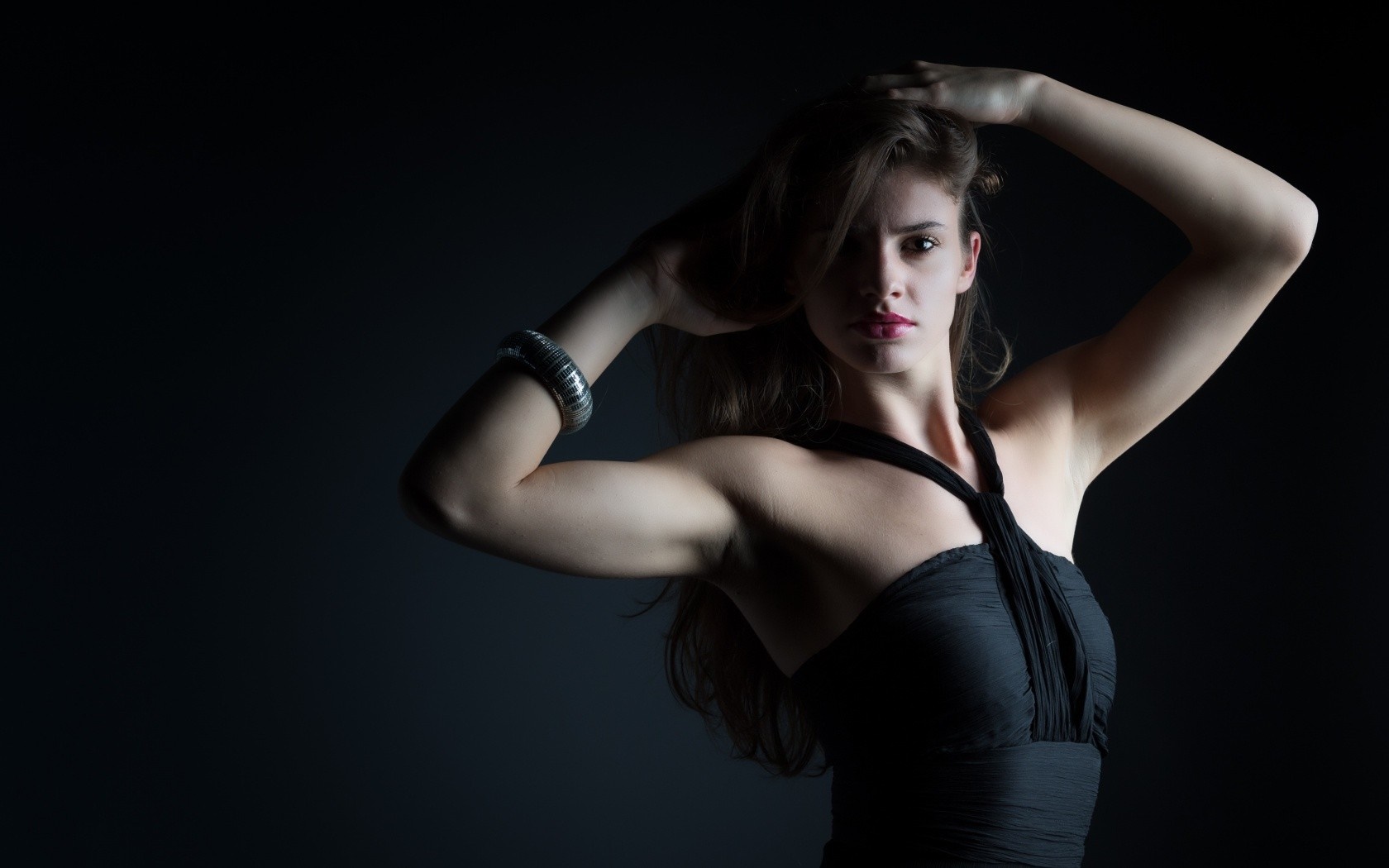 Woman with hands on head in black dress HD Wallpaper