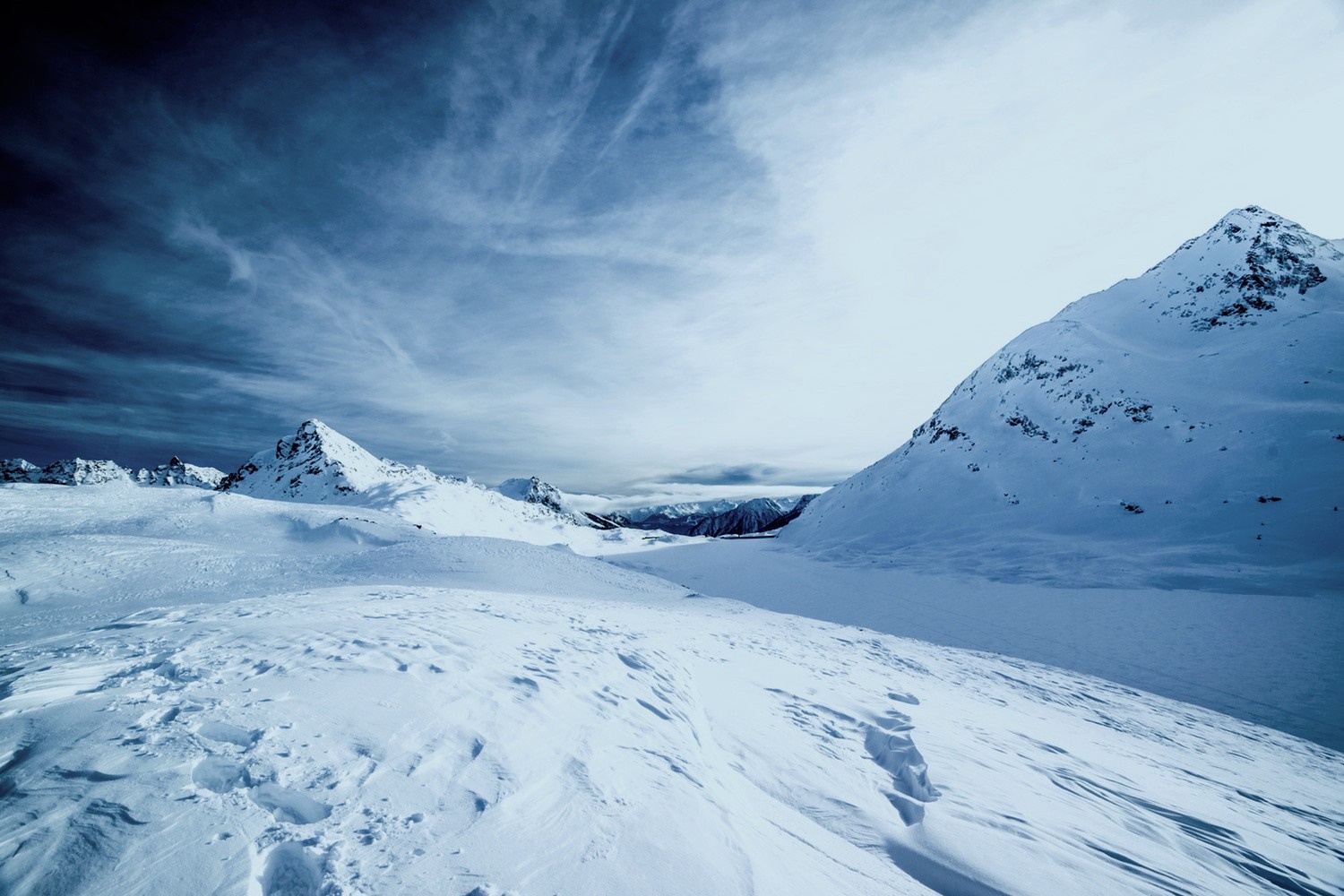 Snowy mountains under a cloudy sky HD Wallpaper