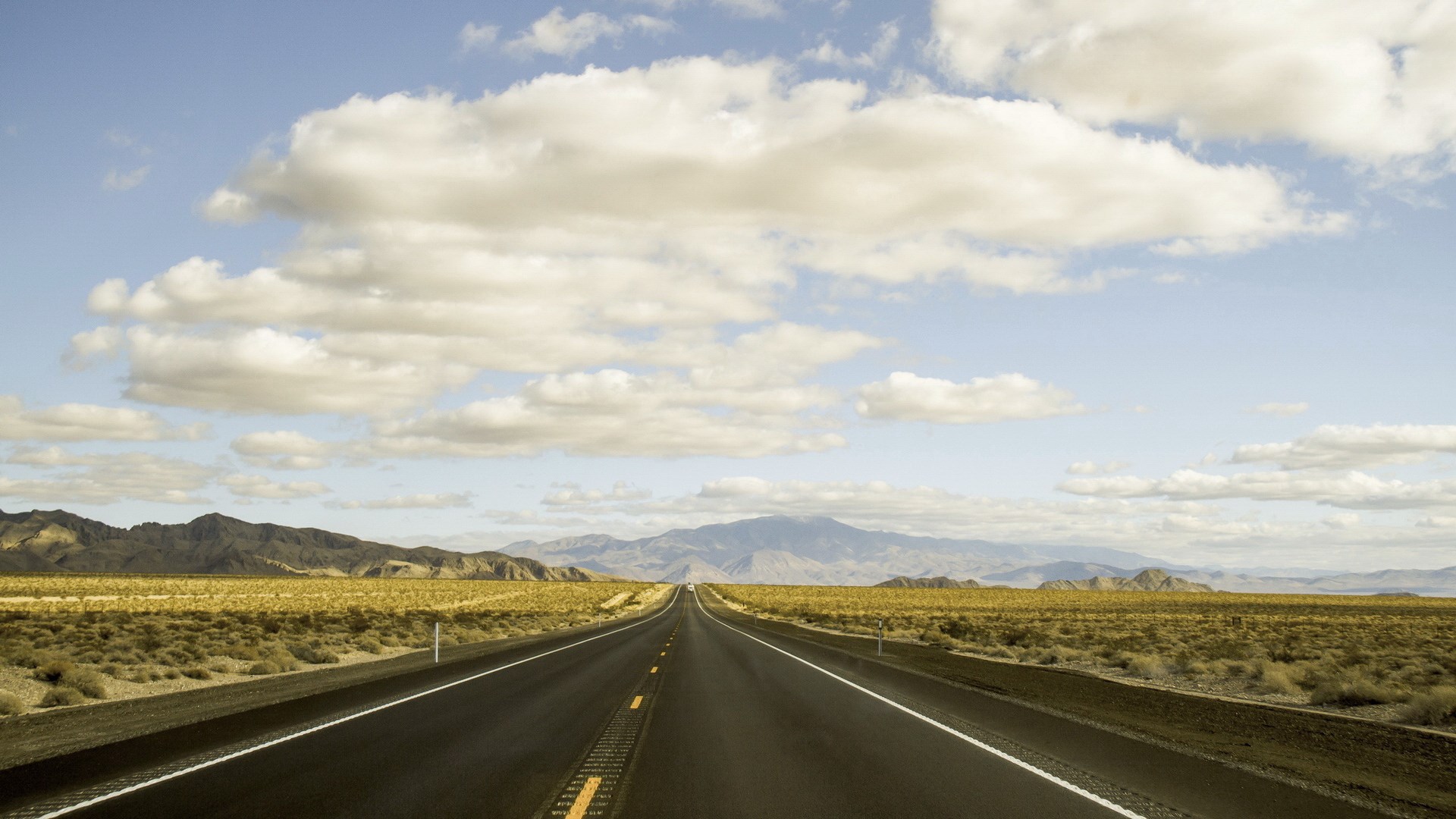Desert highway with mountains and clouds HD Wallpaper