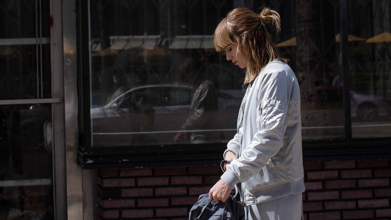 Woman in a bomber jacket holding a bag HD Wallpaper