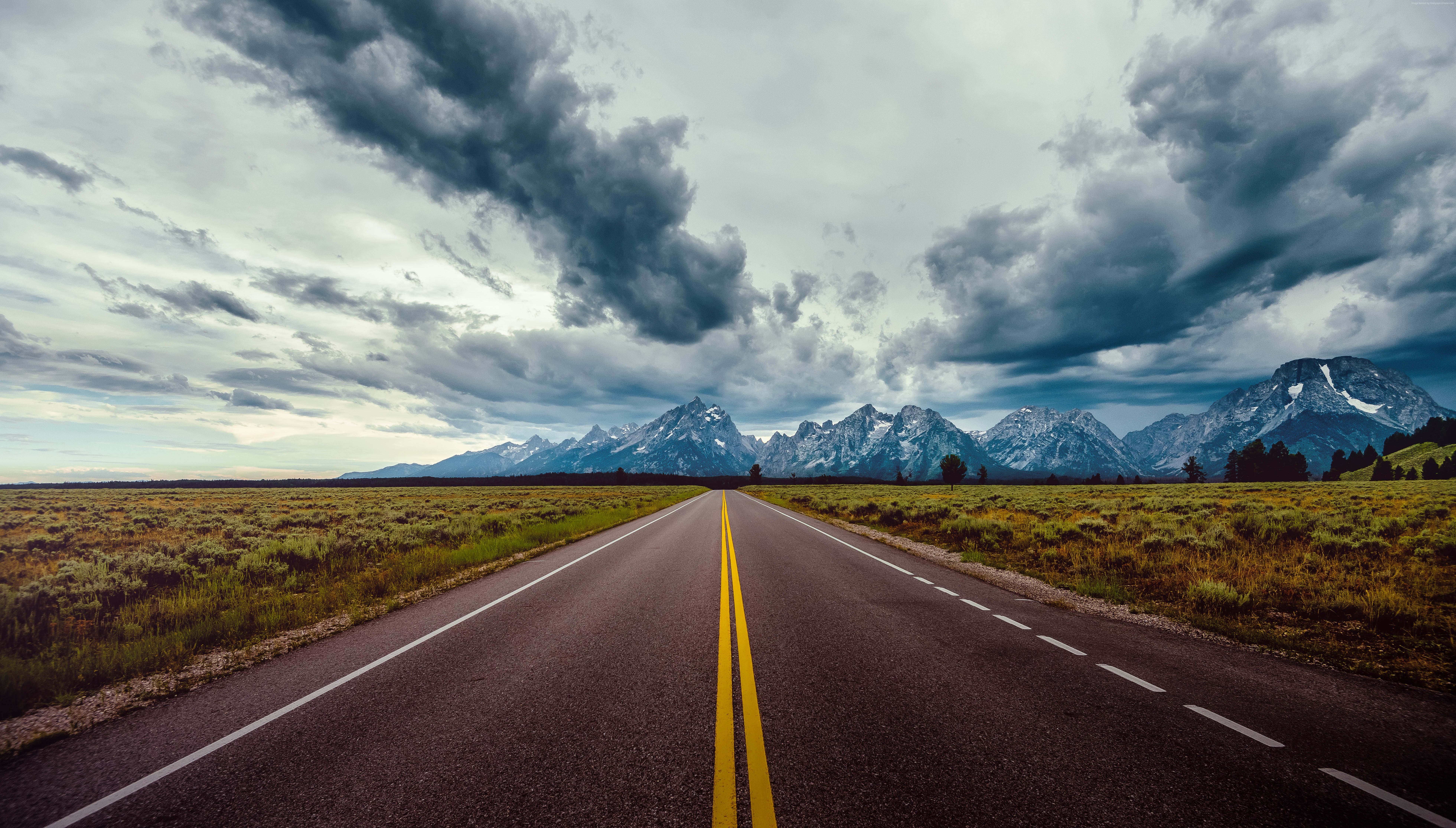 Road leading to mountains under stormy clouds 4K HD Wallpaper