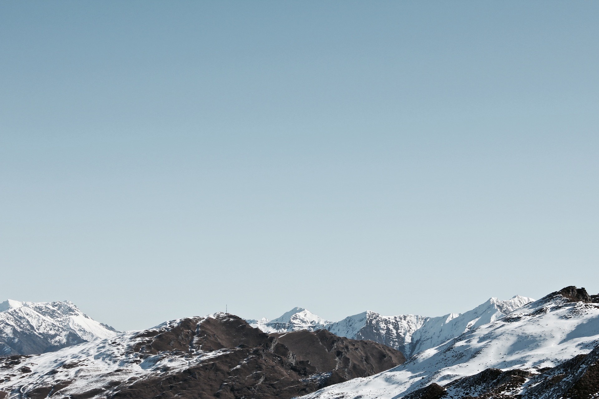 Snow-covered mountains under a clear blue sky HD Wallpaper